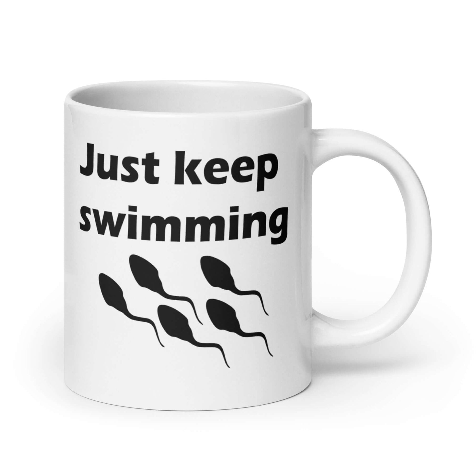 White ceramic coffee mug with the phrase Just keep swimming printed on both sides of the mug. There is an image of some swimming sperm underneath the words.