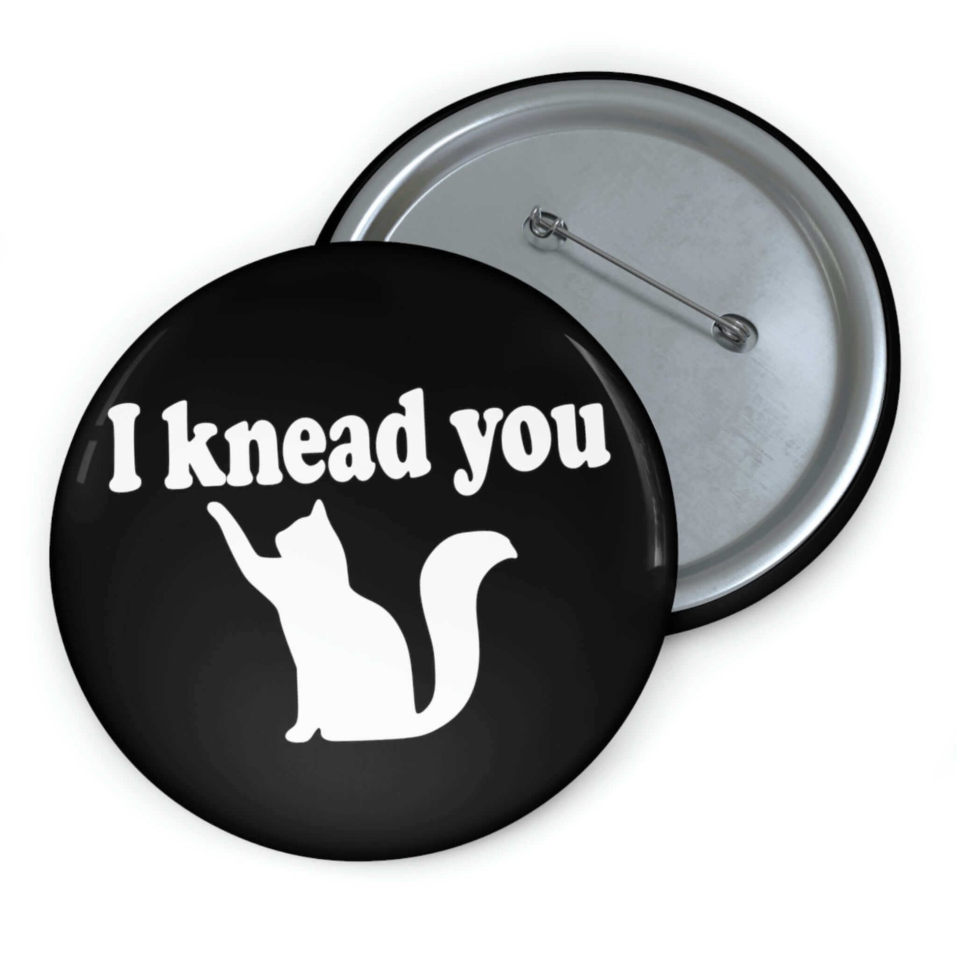 Pin-back button with silhouette of a cat and the words I knead you.