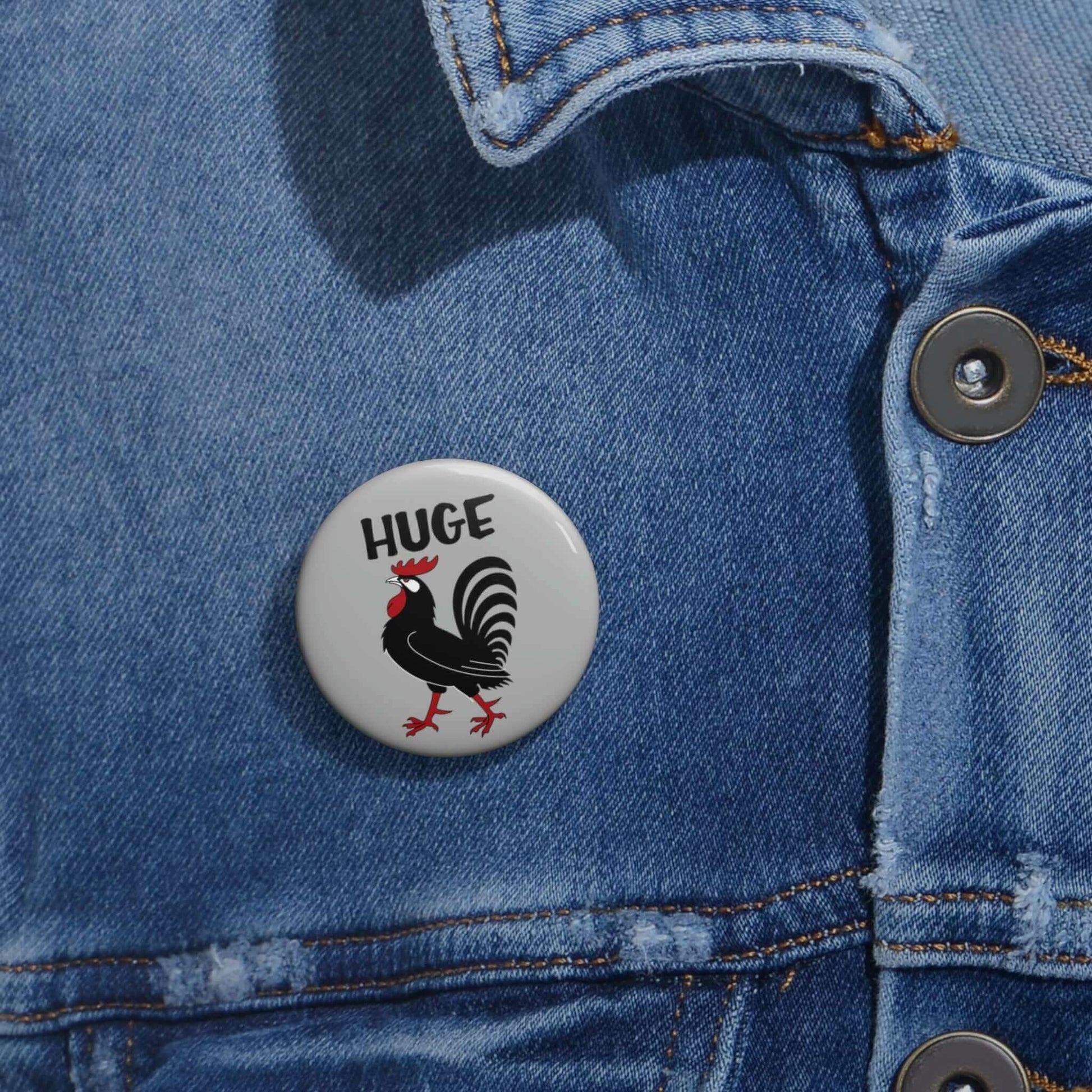Grey pinback button with image of a rooster with the word Huge above the rooster.