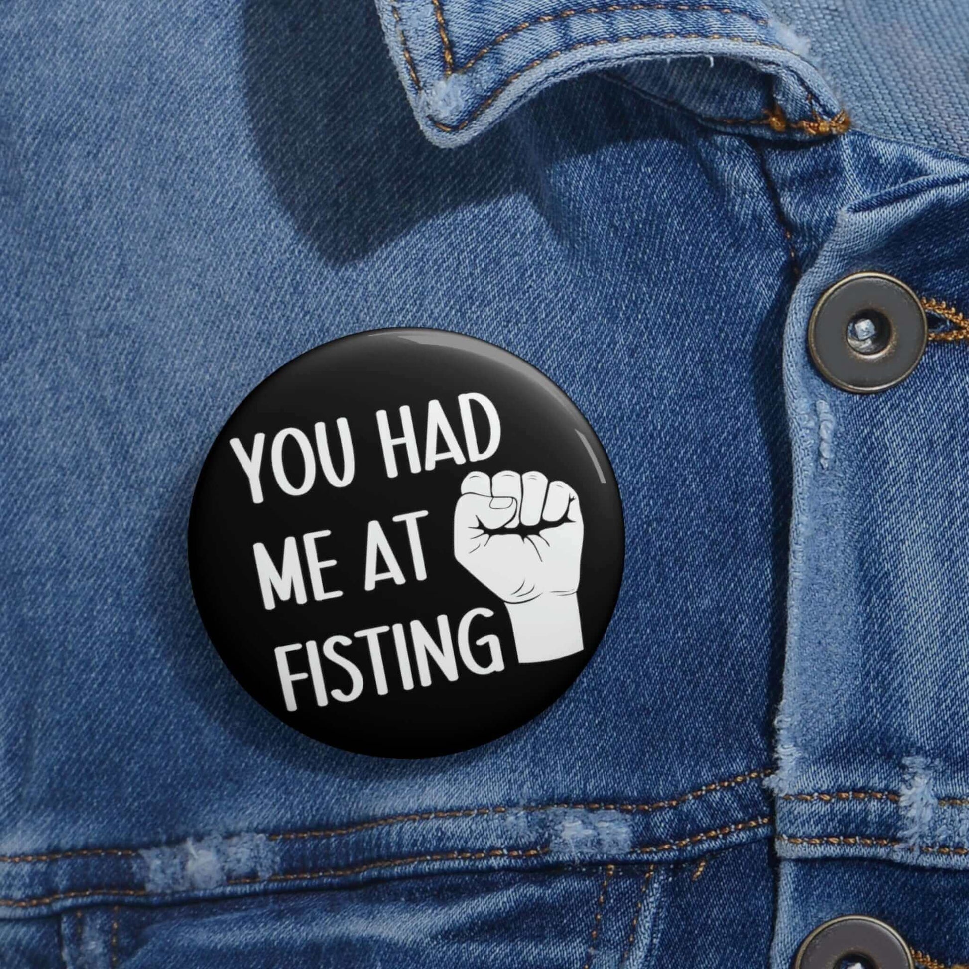 Pin-back button with image of a fist that says you had me at fisting.