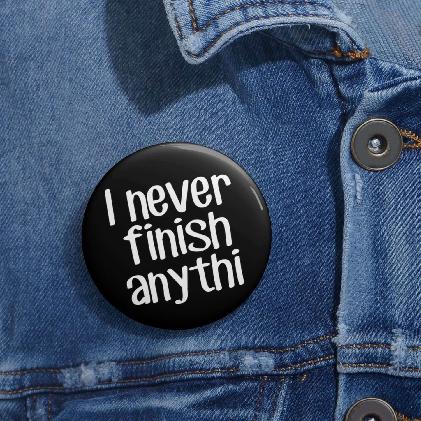 Pin-back button that says I never finish anything with the word anything missing the last 2 letters.