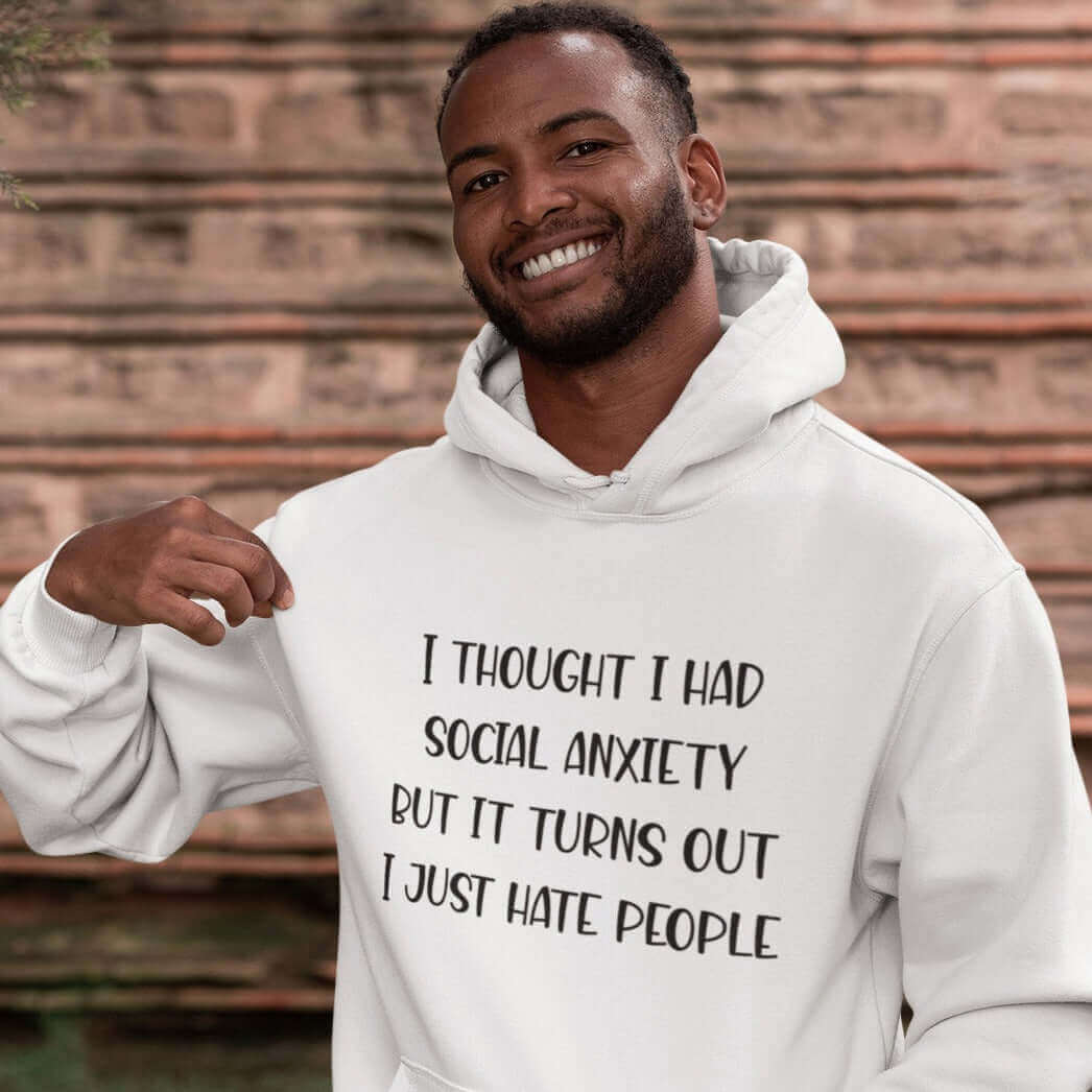 Man wearing white hoodie sweatshirt with the phrase I thought I had social anxiety but it turns out I just hate people printed on the front.