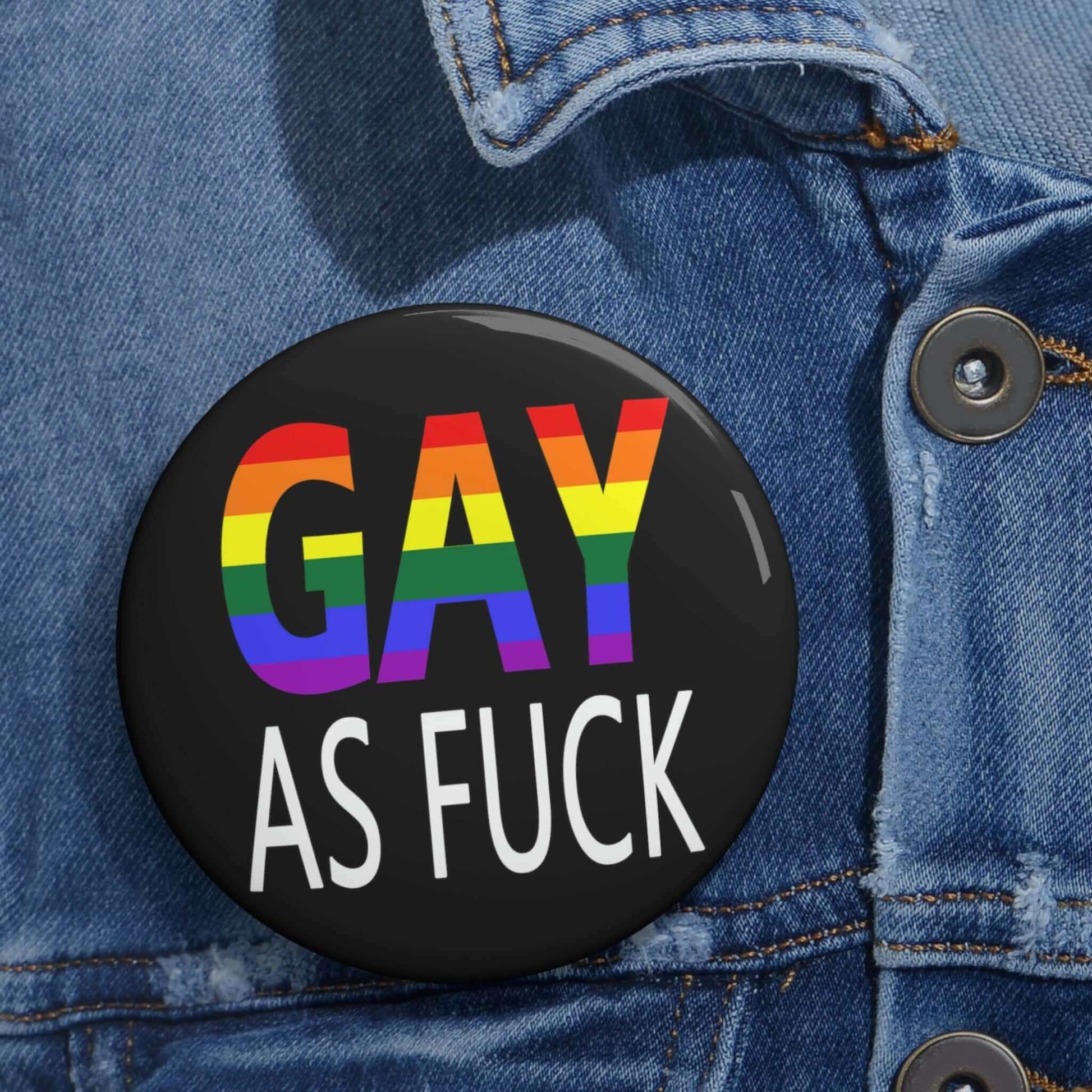 Pin-back button with the words Gay as fuck printed in rainbow font.