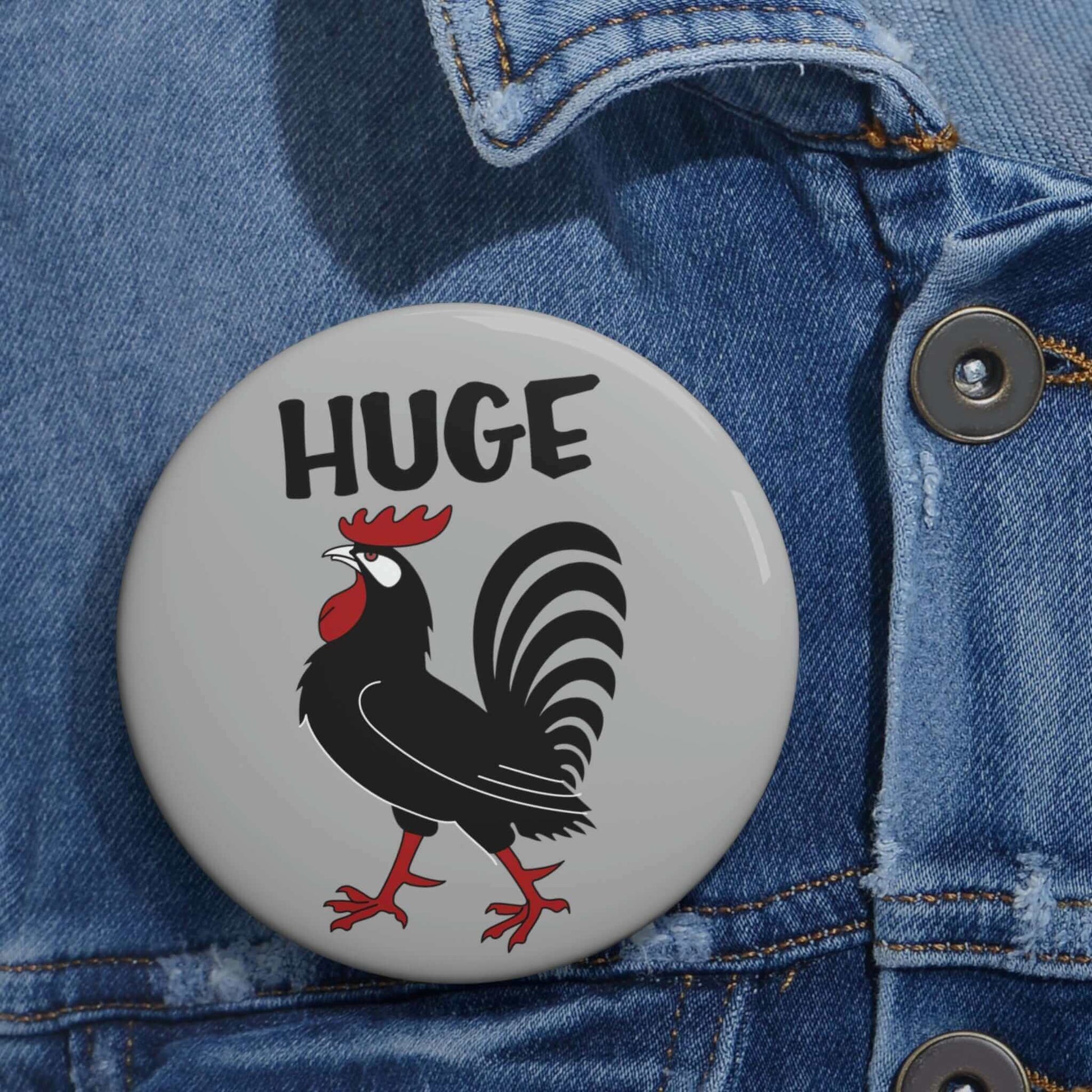 Grey pinback button with image of a rooster with the word Huge above the rooster.