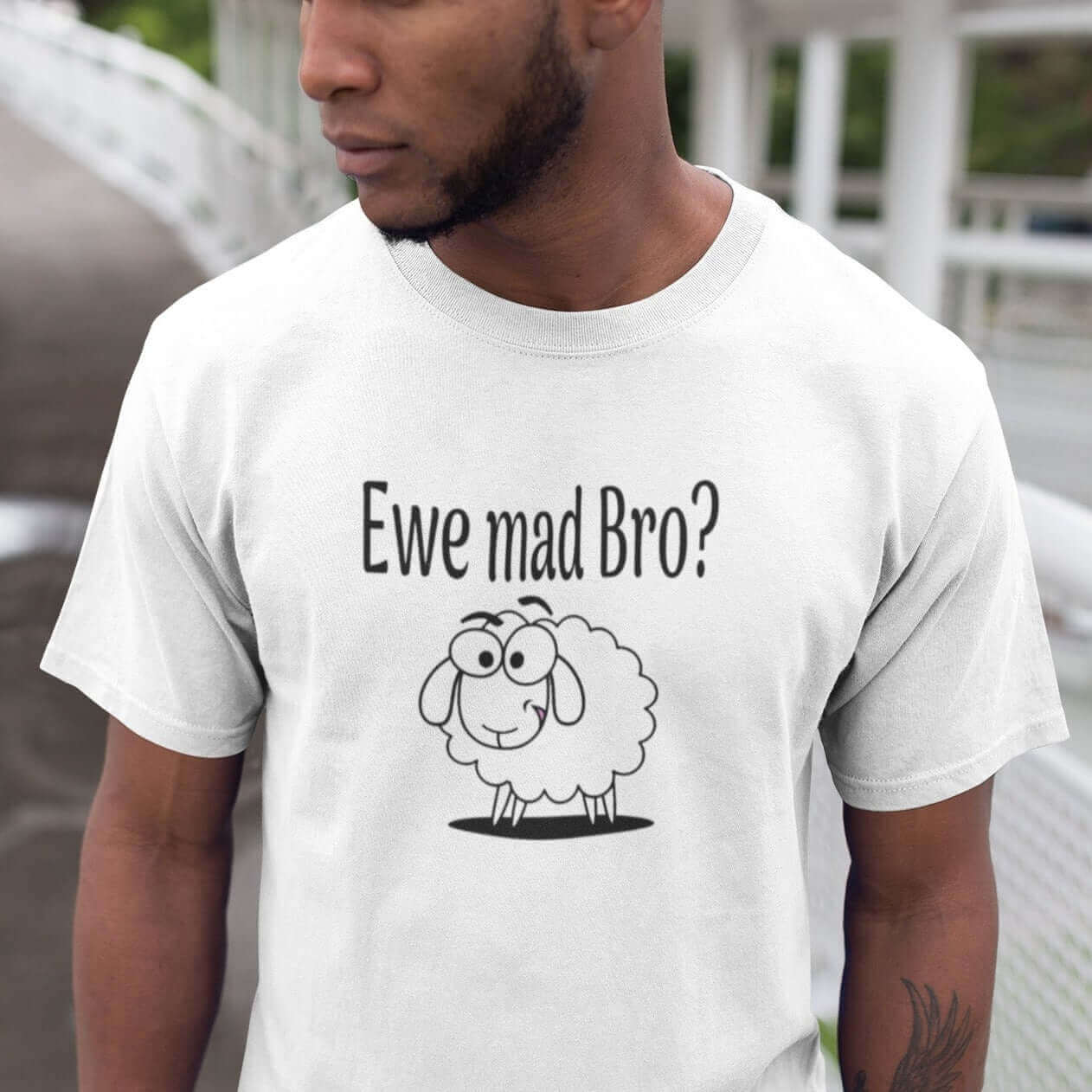 Man wearing a white t-shirt with an image of a sheep and the pun phrase Ewe mad bro question mark printed on the front.