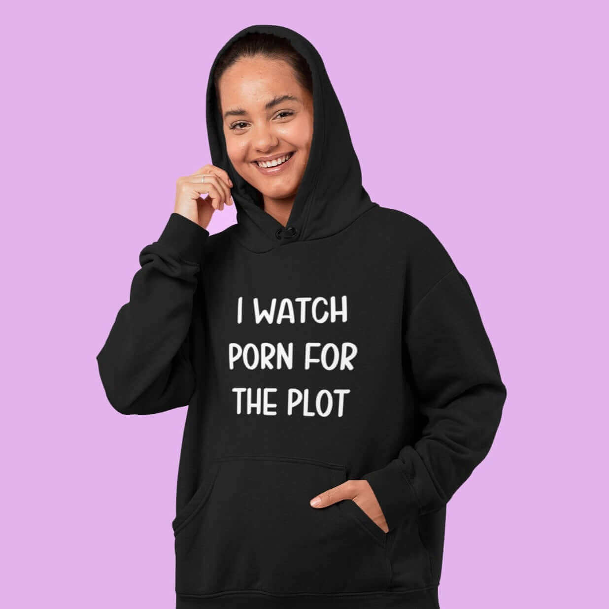 Woman wearing black hoodie sweatshirt with the words I watch porn for the plot printed on the front.