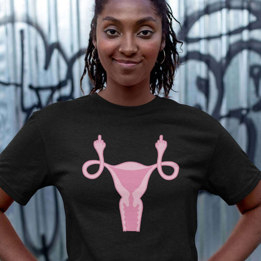 woman wearing black t-shirt with pink uterus flipping middle finger graphic printed on it by witticisms r us