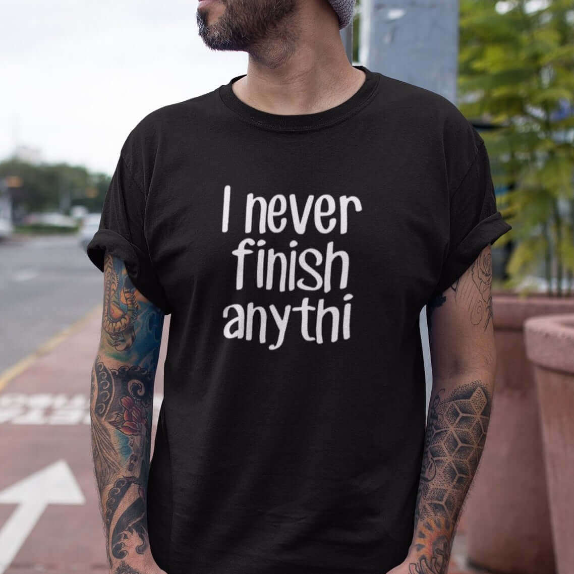 Man wearing a black t-shirt with the phrase I never finish anything printed on the front The letters n and g are missing from the word anything.