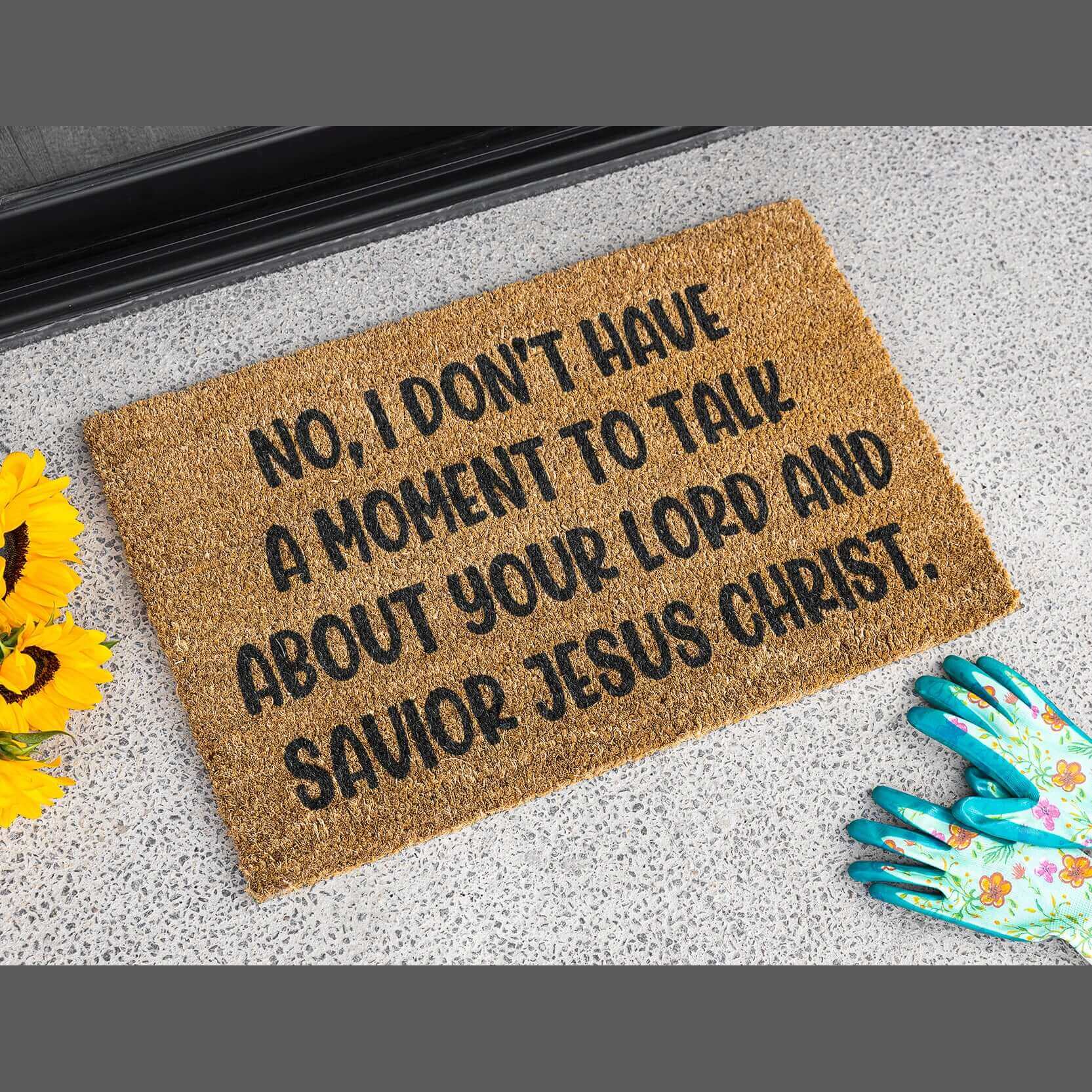 Tan color coconut coir fiber doormat with the phrase No, I don't have a moment to talk about your lord and savior Jesus Christ printed in black.