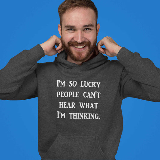 Man wearing dark grey hooded sweatshirt that has the words I'm so lucky people can't hear what I'm thinking printed on the front.