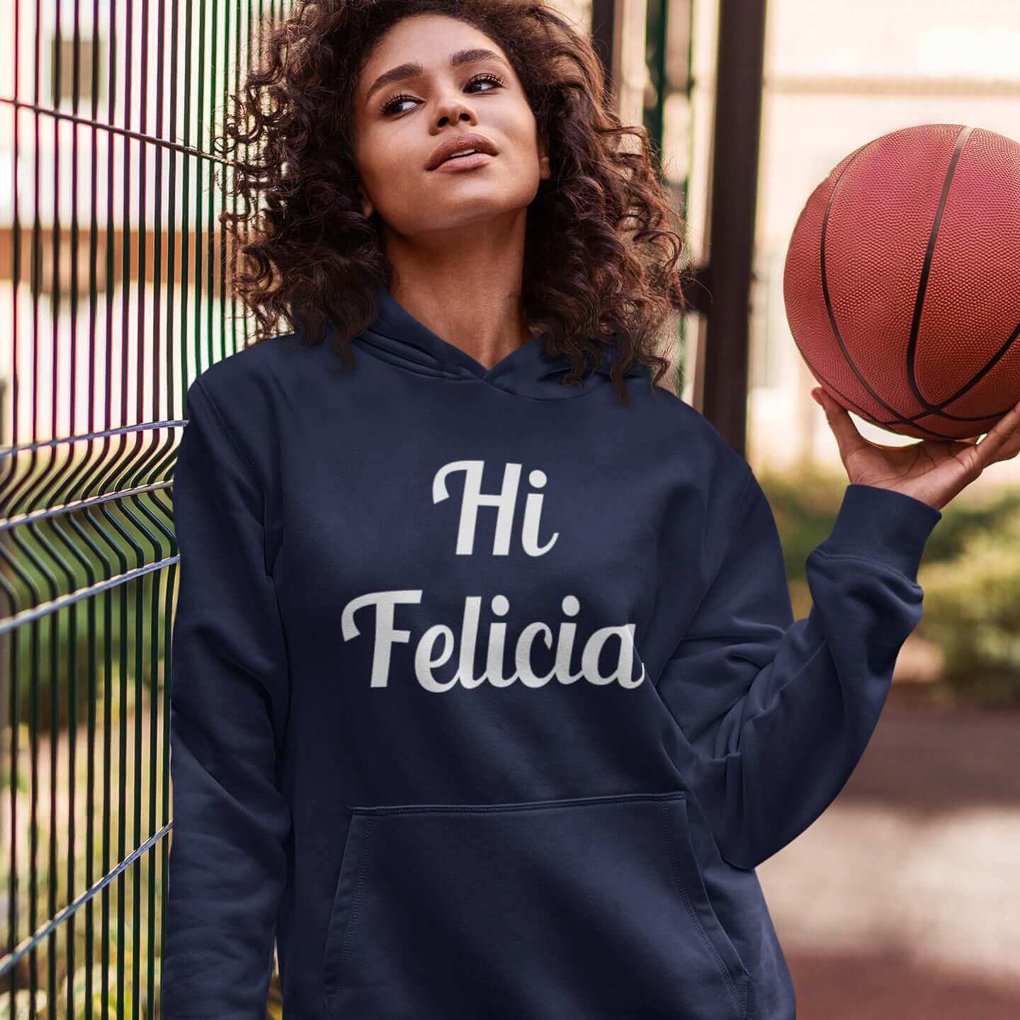 Woman wearing a navy blue hoodie sweatshirt with the words Hi Felicia printed on the front.