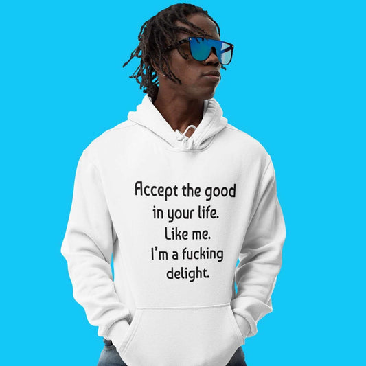 Man wearing a white hoodie sweatshirt with the funny phrase Accept the good in your life, like me, I'm a fucking delight printed on the front. 