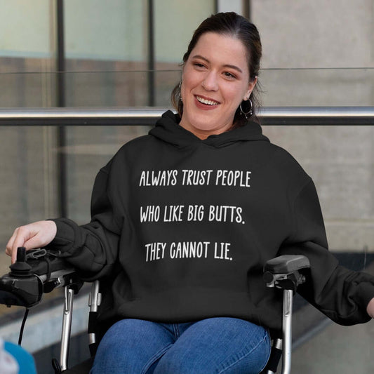 Woman in a wheelchair wearing a black hoodie sweatshirt with the funny phrase Always trust people who like big butts, they can not lie printed on the front.