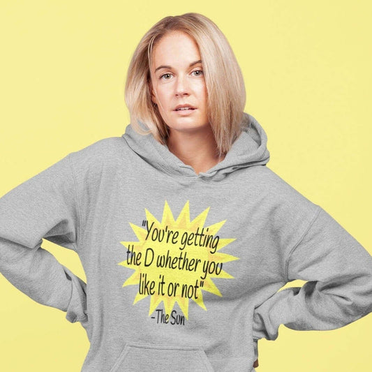 Woman wearing a light grey hoodie sweatshirt with image of the sun and the quote You're getting the D whether you like it or not printed on the front.