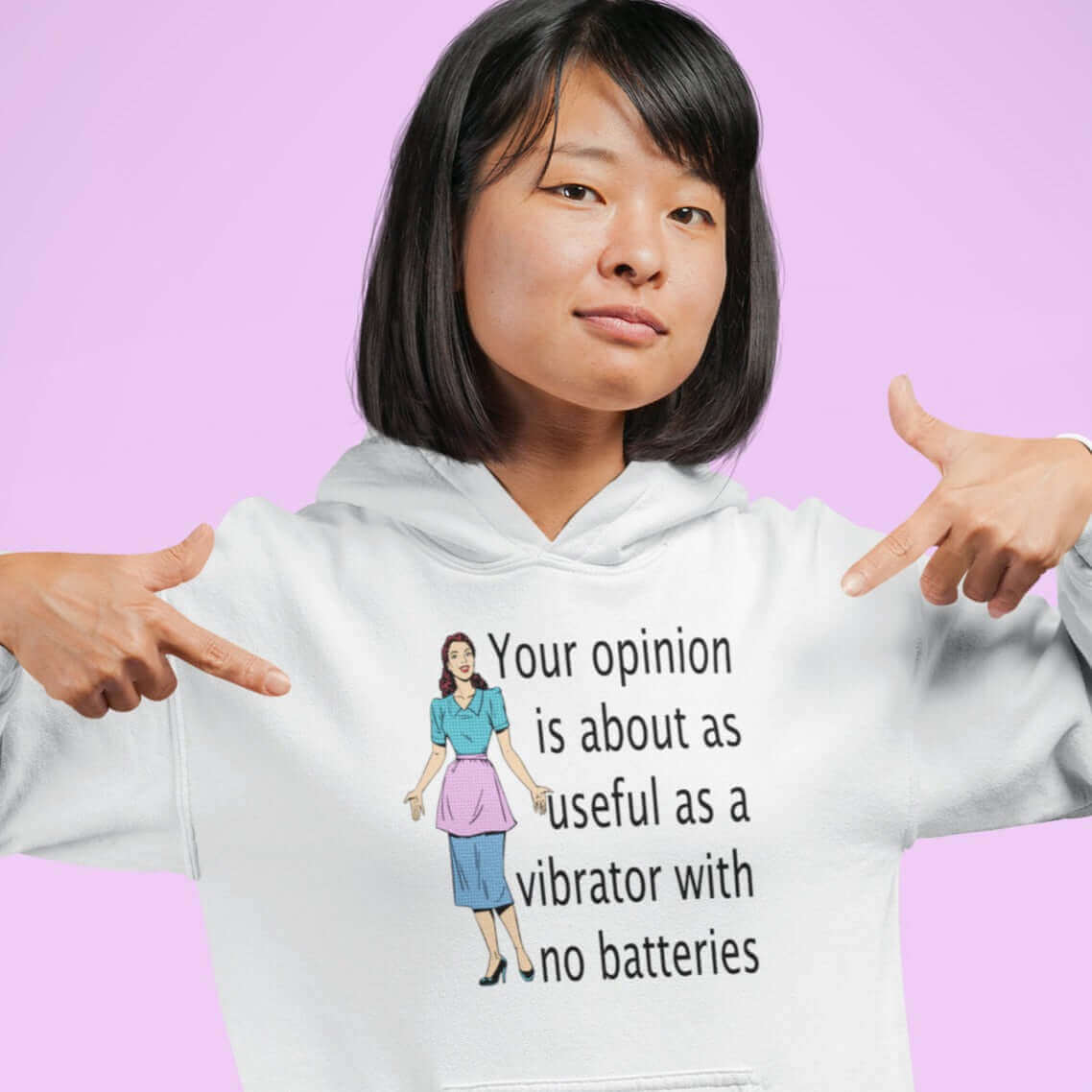 Woman wearing a white hoodie sweatshirt with an image of a retro woman and the phrase Your opinion is about as useful as a vibrator with no batteries printed on the front.