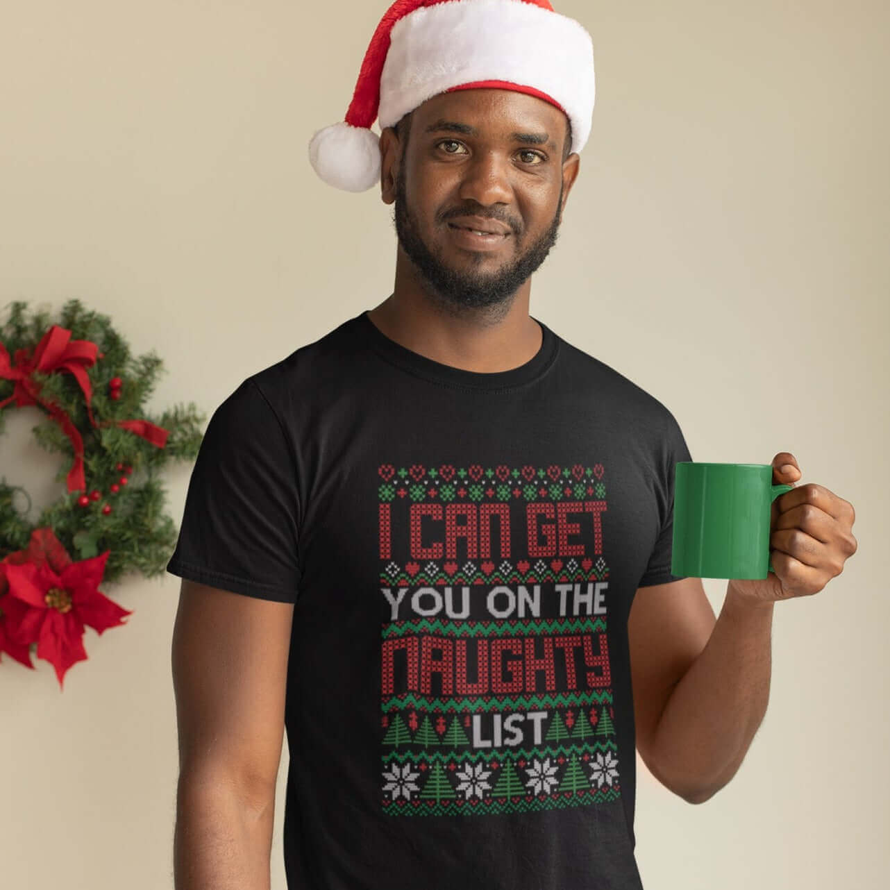 Man wearing santa hat wearing black t-shirt with the words I can get you on the naught list printed on the front. 