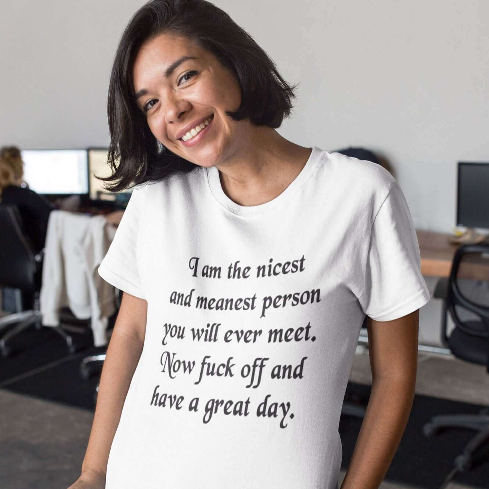 Smiling woman wearing a white t-shirt with the funny phrase I am the nicest and meanest person you will ever meet. Now fuck off and have a great day printed on the front.