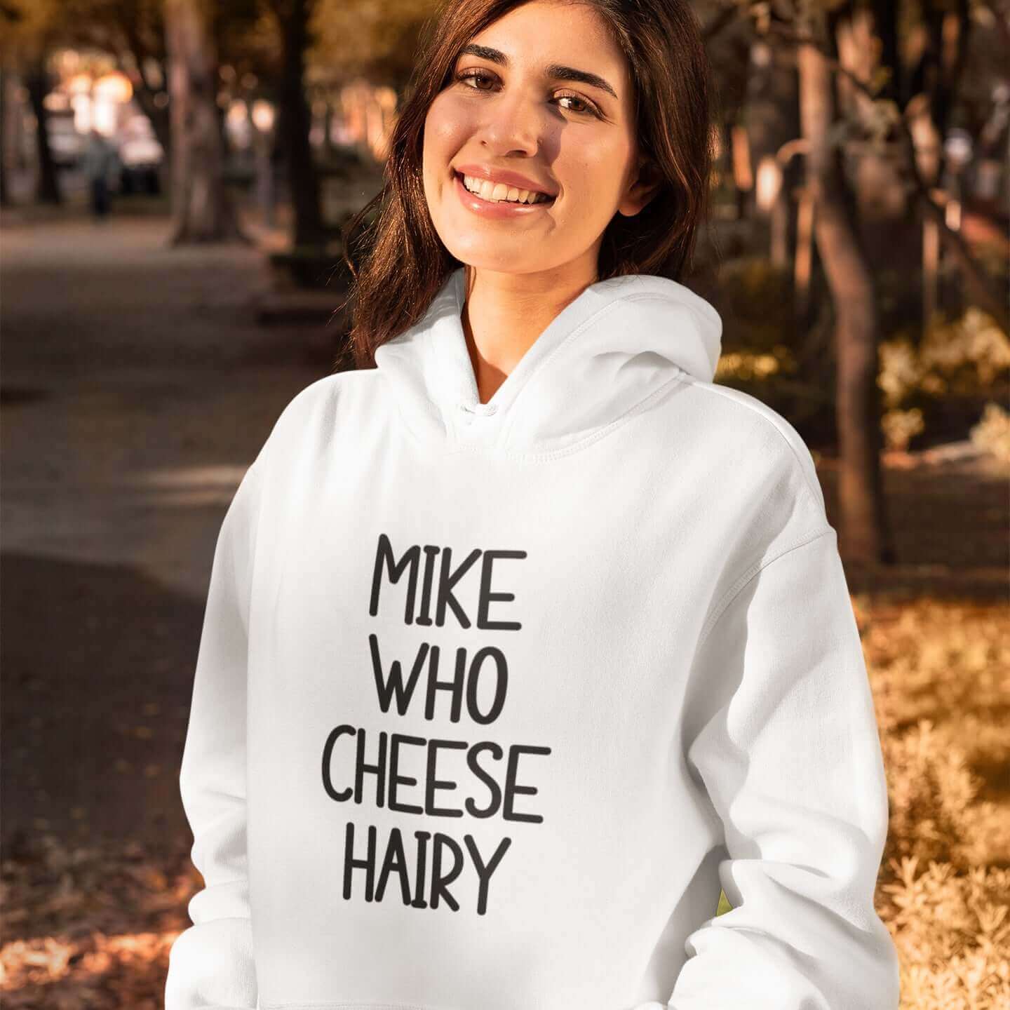 Grinning woman wearing white pun hoodie sweatshirt with the words Mike who cheese hairy printed on the front.