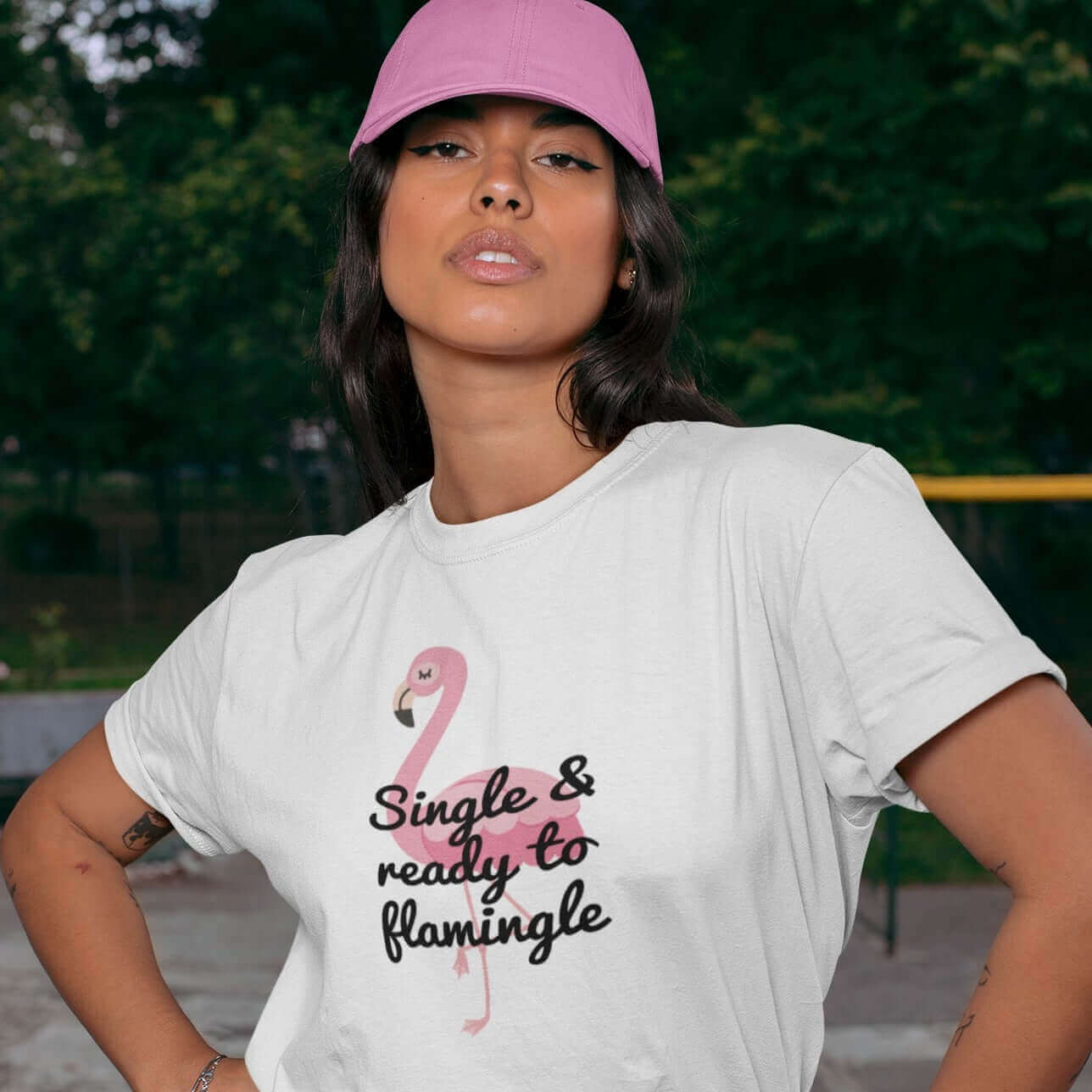 Woman wearing pink hat and funny flamingo animal pun T-shirt. The t-shirt is white and has an image of a flamingo and the words Single and ready to flamingle printed on the front.