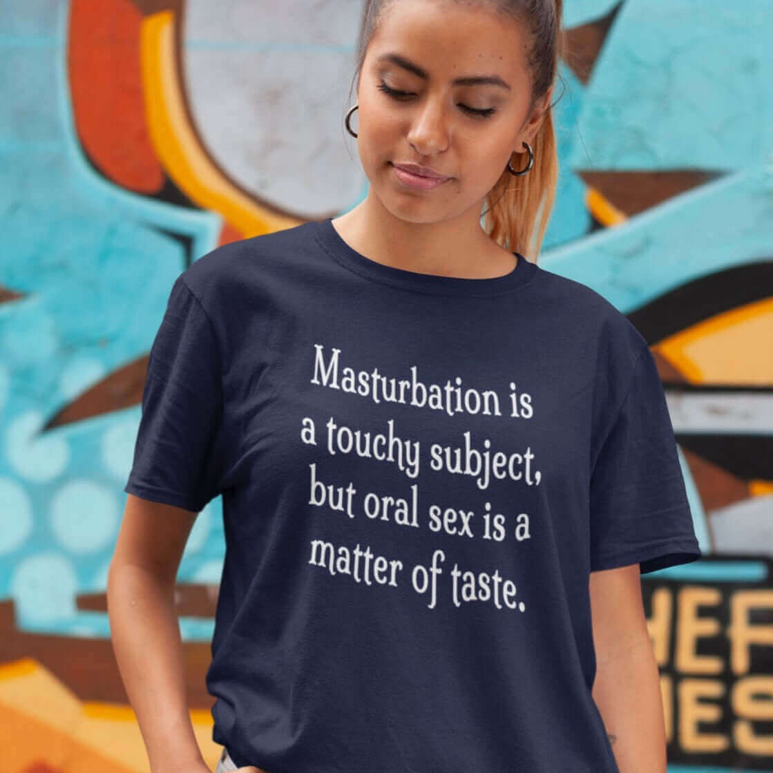 Woman wearing a navy blue t-shirt with the suggestive phrase Masturbation is a touchy subject, but oral sex is a matter of taste printed on the front.