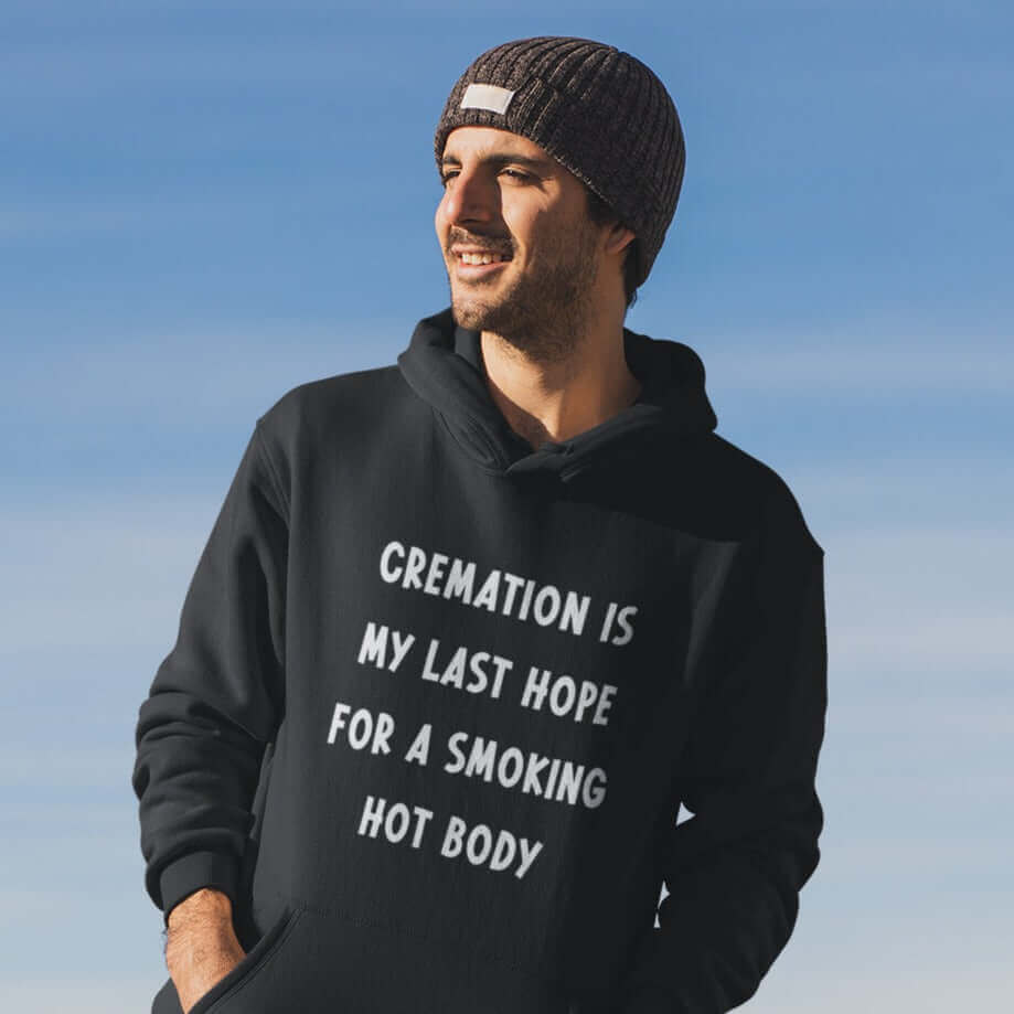Man wearing black hooded sweatshirt with the words Cremation is my last hope for a smoking hot body printed on the front.