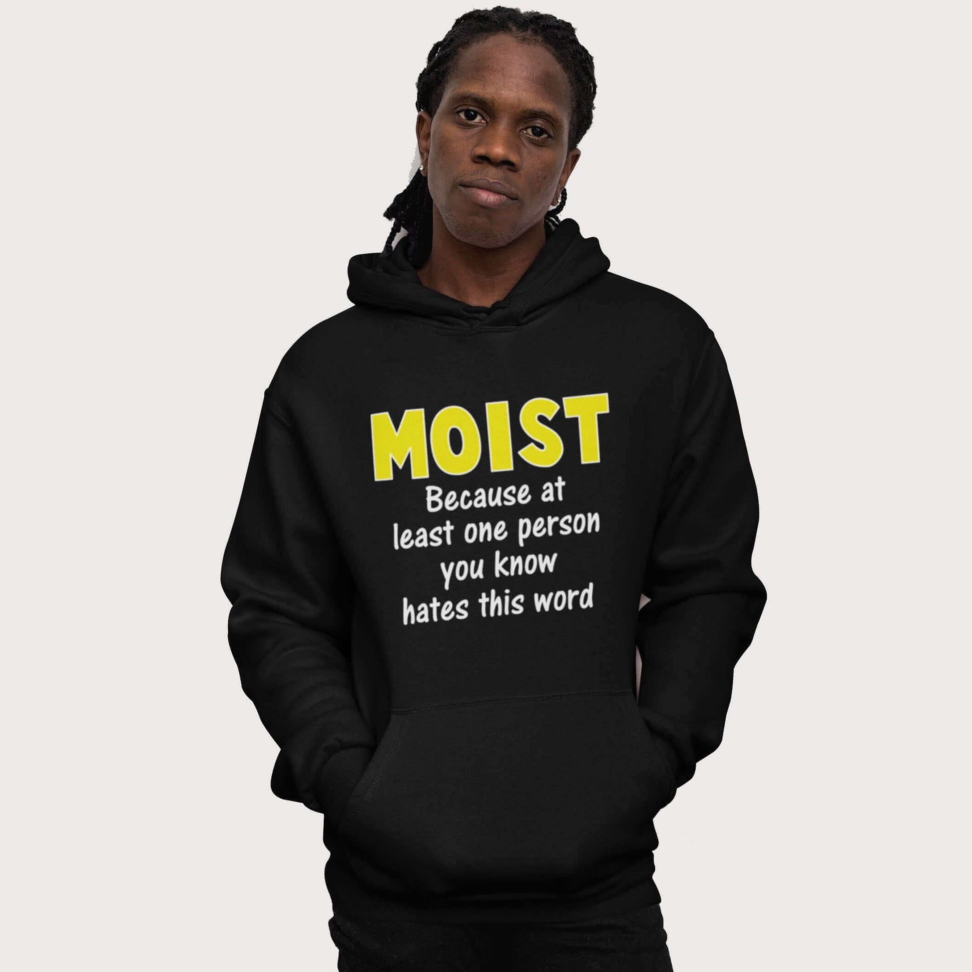 Man wearing a black hoodie sweatshirt with the word Moist printed in large yellow bold font. In smaller font under the word moist is the phrase Because at least one person you know hates this word. 