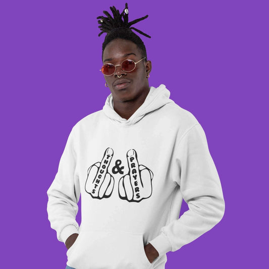 Man wearing a white hoodie sweatshirt with an image of 2 line drawing hands with the middle fingers up. The word Thoughts is printed on one middle finger and the word Prayers is printed on the other middle finger. The graphics are printed on the front of 