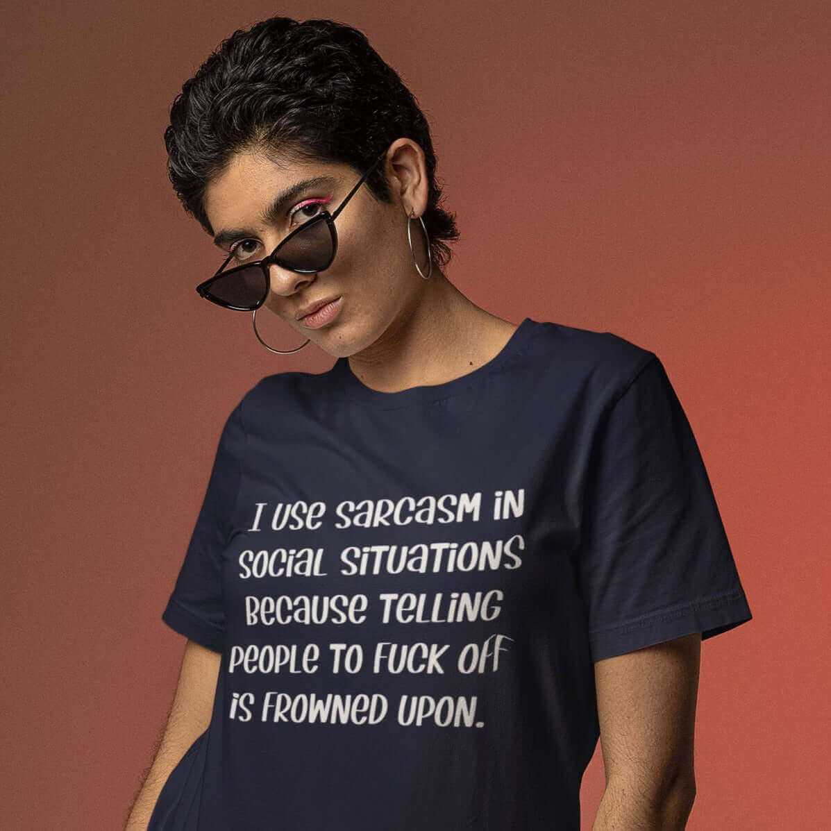 Short haired woman wearing navy blue t-shirt with the phrase I use sarcasm in social situations because telling people to fuck off is frowned upon printed on the front.