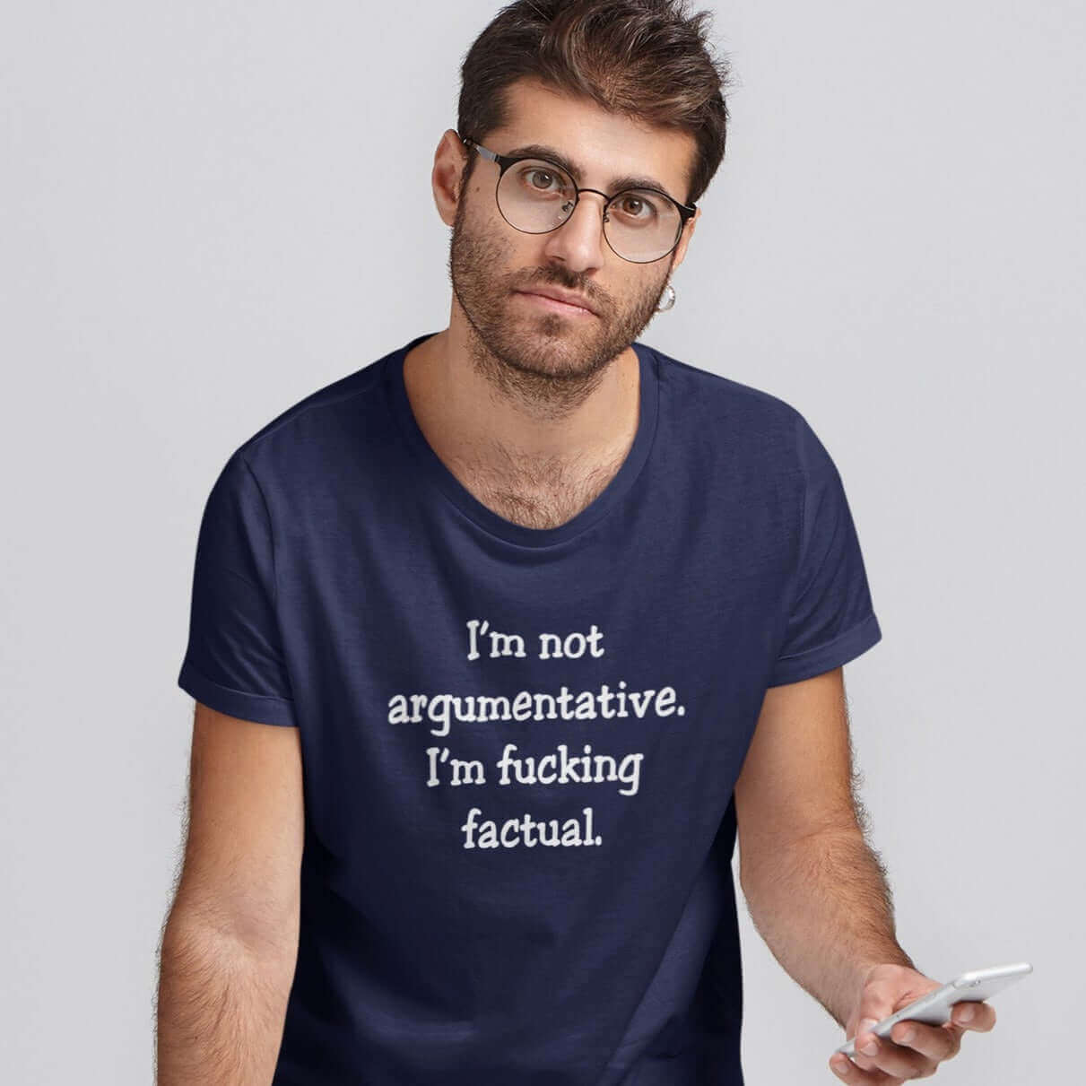 Man wearing a navy blue t-shirt with the phrase I'm not argumentative. I'm fucking factual printed on the front.