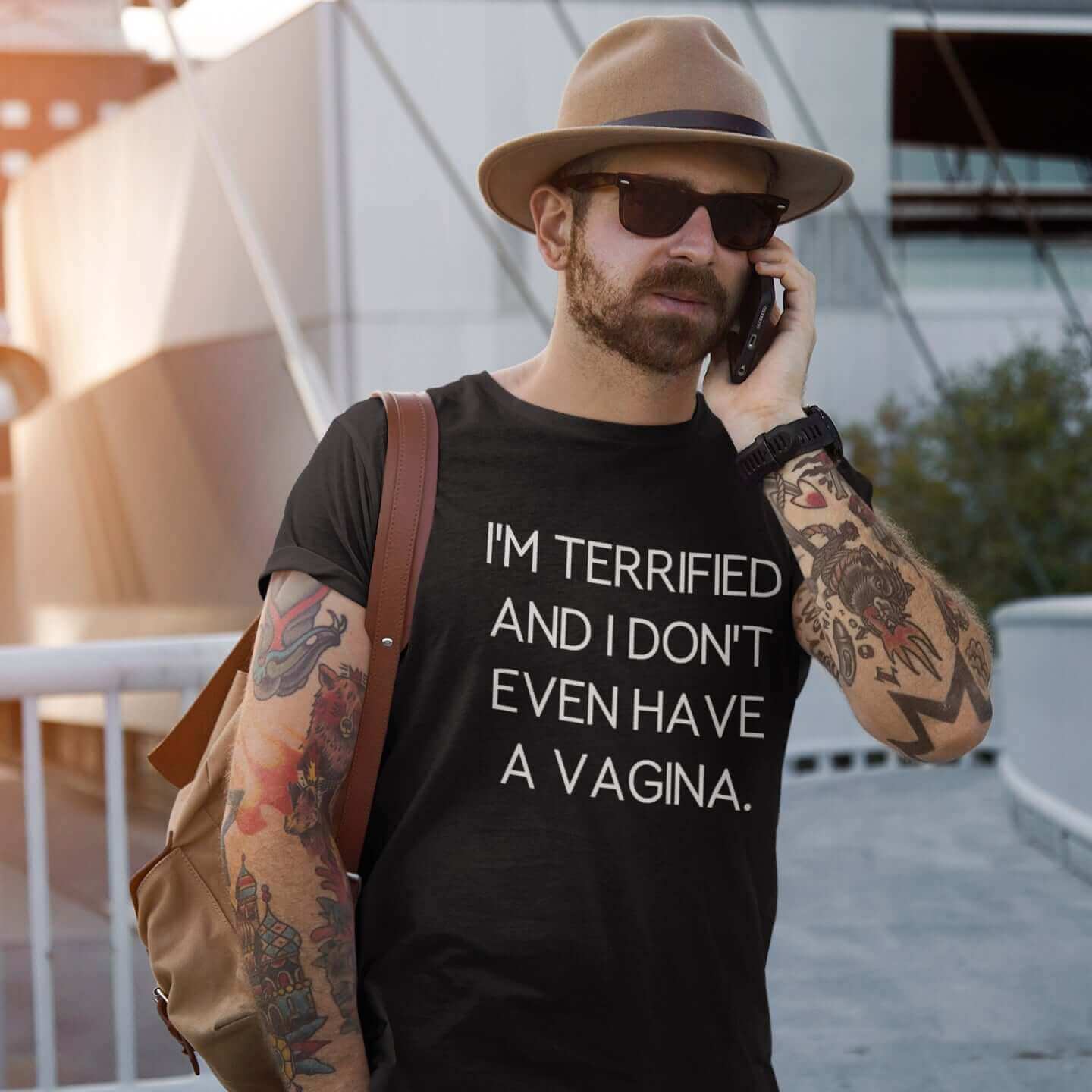 Man wearing a hat and black t-shirt with the words I'm terrified and I don't even have a vagina printed on the front.