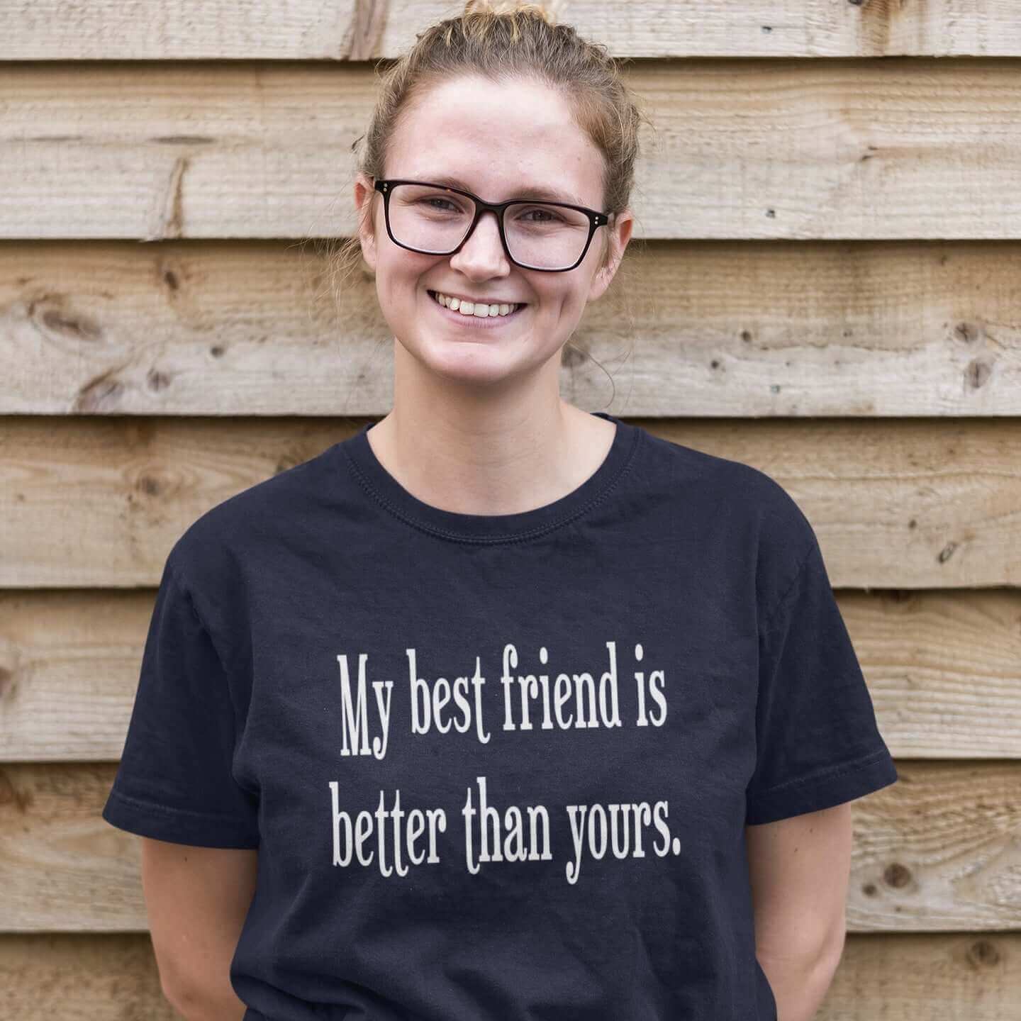 Smiling woman wearing a navy blue t-shirt with the phrase My best friend is better than yours printed on the front.