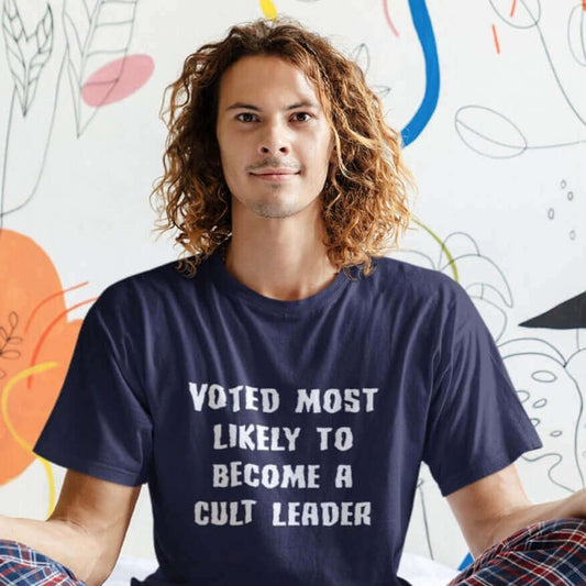 Curly haired man wearing navy blue t-shirt with the words Voted most likely to become a cult leader printed on the front.