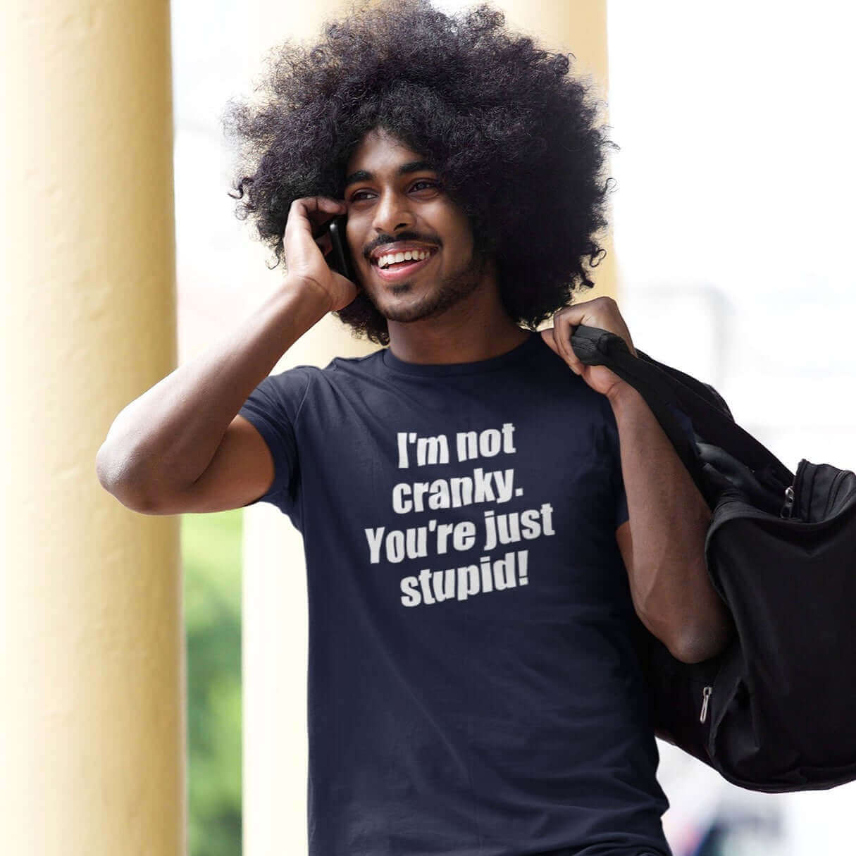 Man wearing a navy blue t-shirt with the phrase I'm not cranky You're just stupid printed on the front.