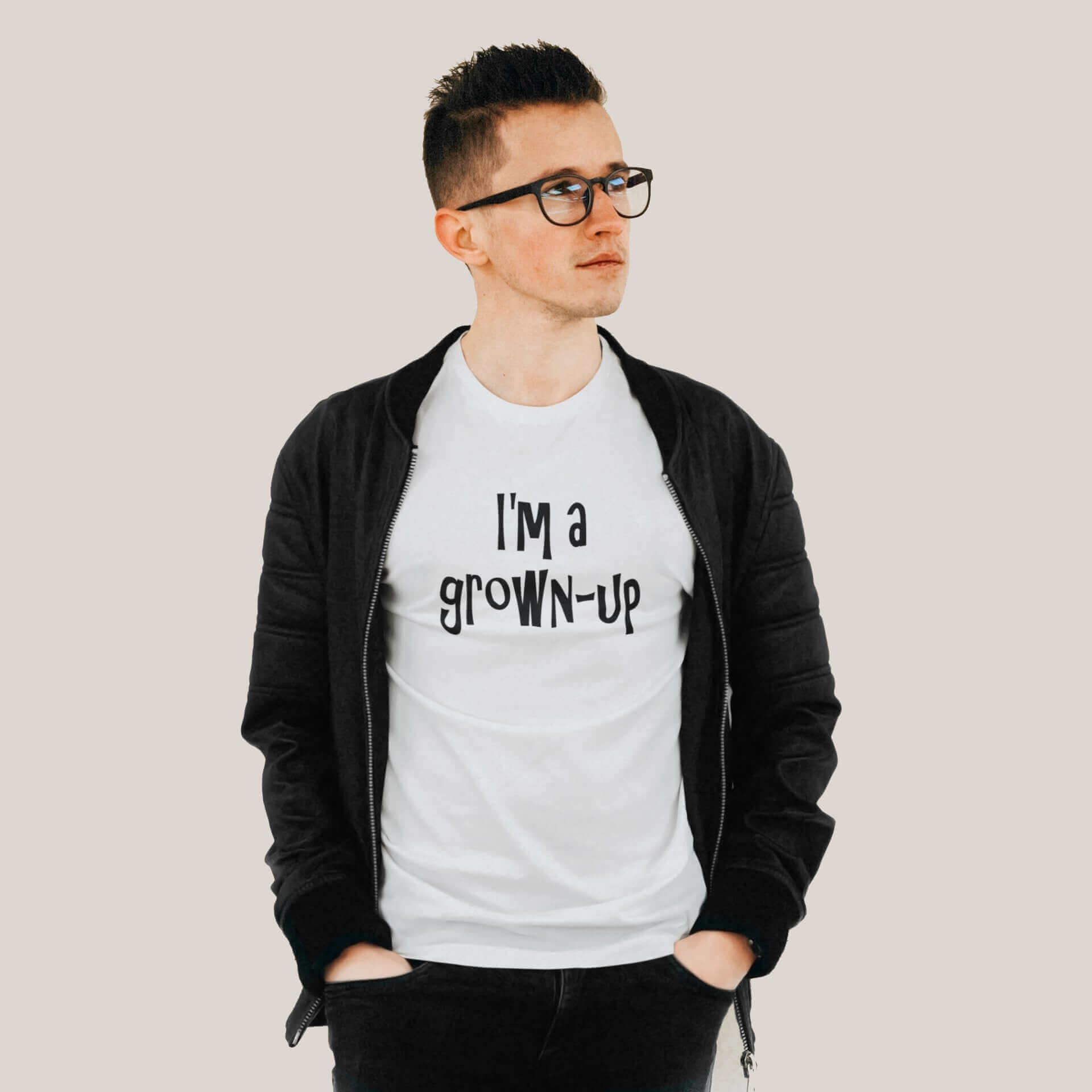 Young man wearing a white t-shirt with the words I'm a grown-up printed on the front of the shirt.