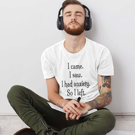 Man wearing headphones and a white t-shirt with the phrase I came. I saw. I had anxiety. So I left printed on the front of the shirt.