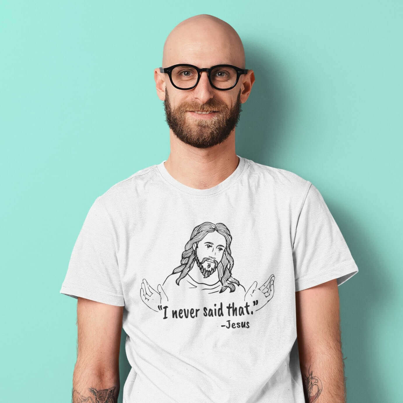 Bald man wearing a white t-shirt with a line drawing of Jesus with his hands outstretched and the quote I never said that printed on the front.