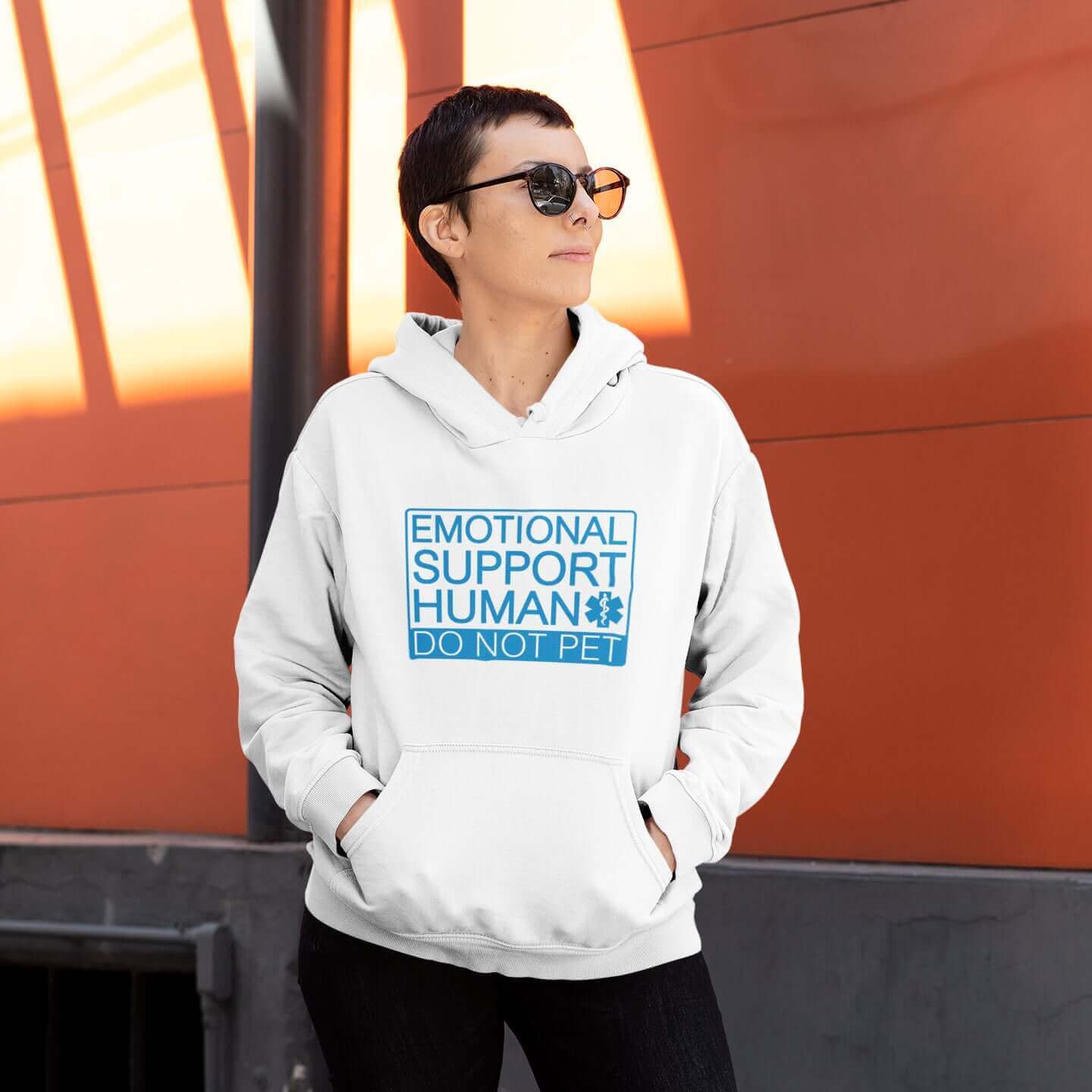 Woman wearing white hoodie sweatshirt with the words Emotional support human, do not pet printed on the front. 