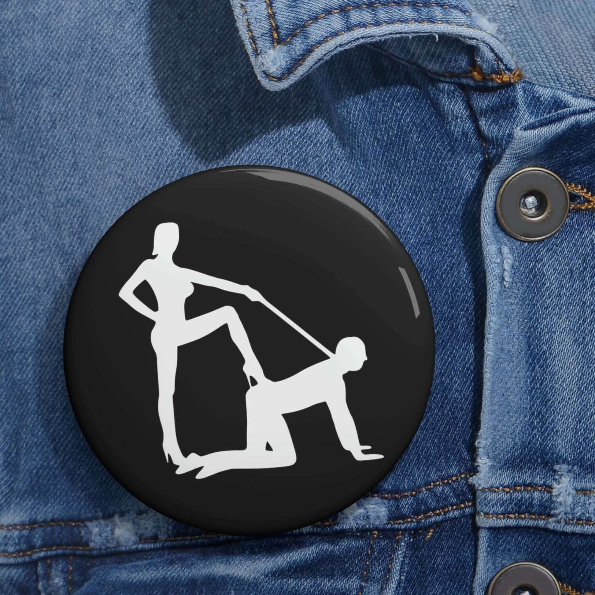 Pin-back button with silhouette image of a man on his hands and knees and a dominatrix holding his leash.
