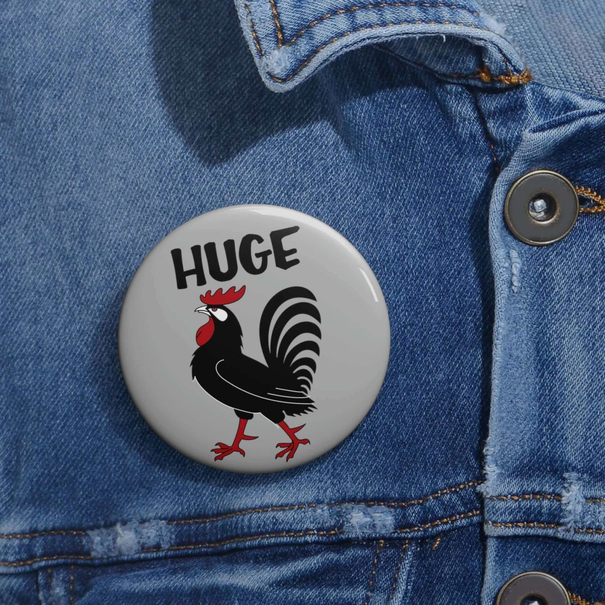 Grey pinback button with image of a rooster with the word Huge above the rooster.