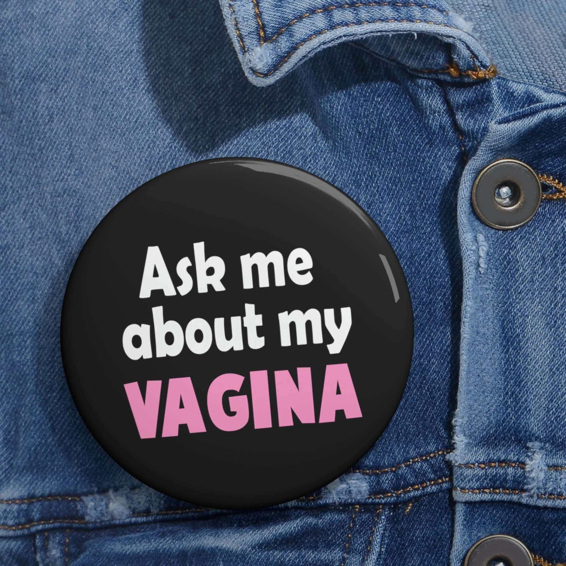 Black pinback button that says Ask me about my vagina. The word vagina is printed in pink. The rest of the text is white.