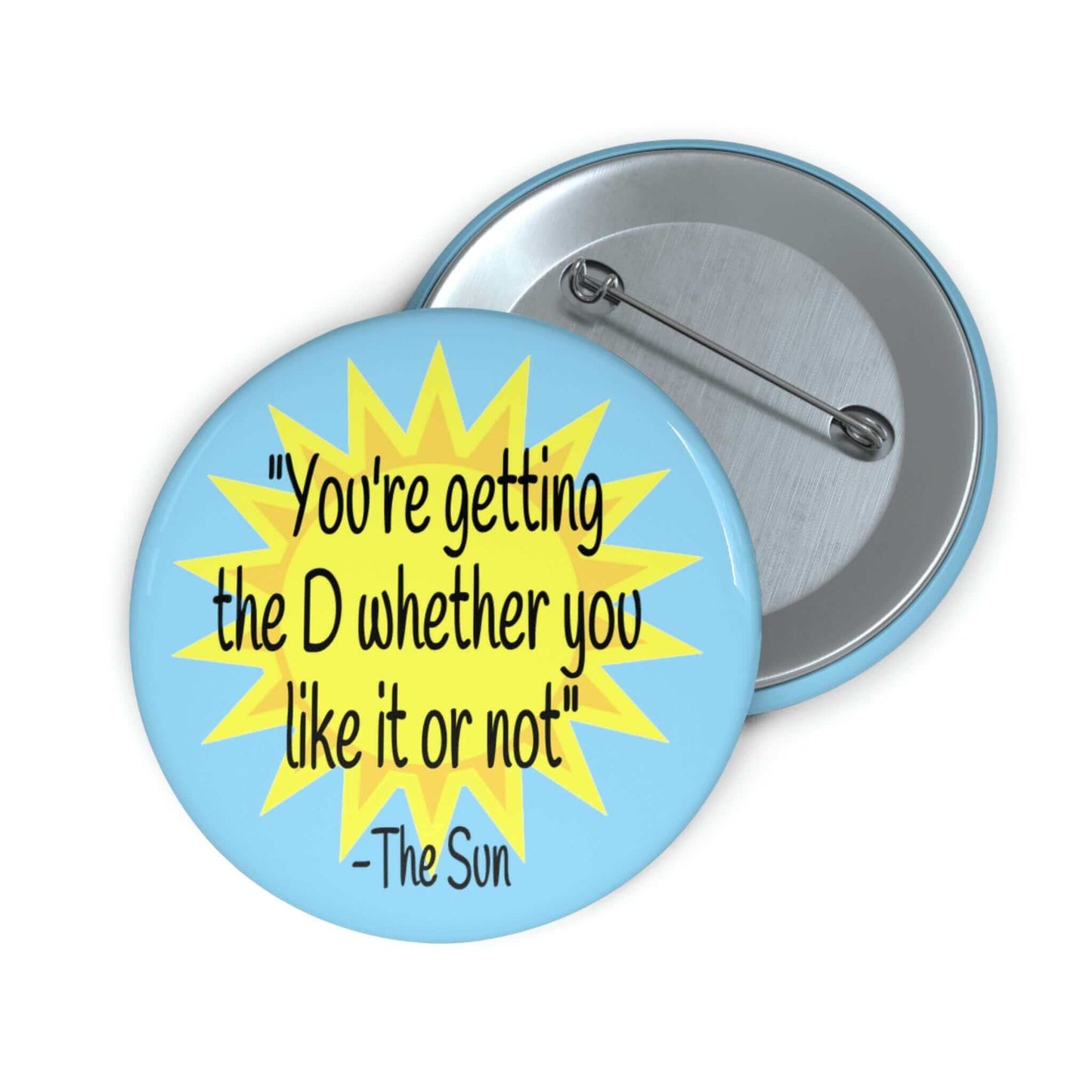 Pinback button with image of the sun and the quote You're getting the D whether you like it or not printed on it.