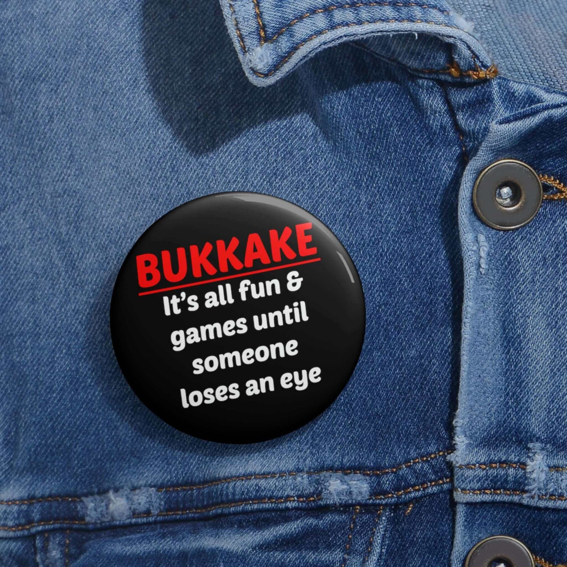 Black pinback button that says Bukkake it's all fun & games until someone loses an eye.