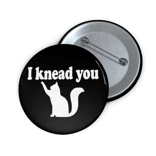 Pin-back button with silhouette of a cat and the words I knead you.