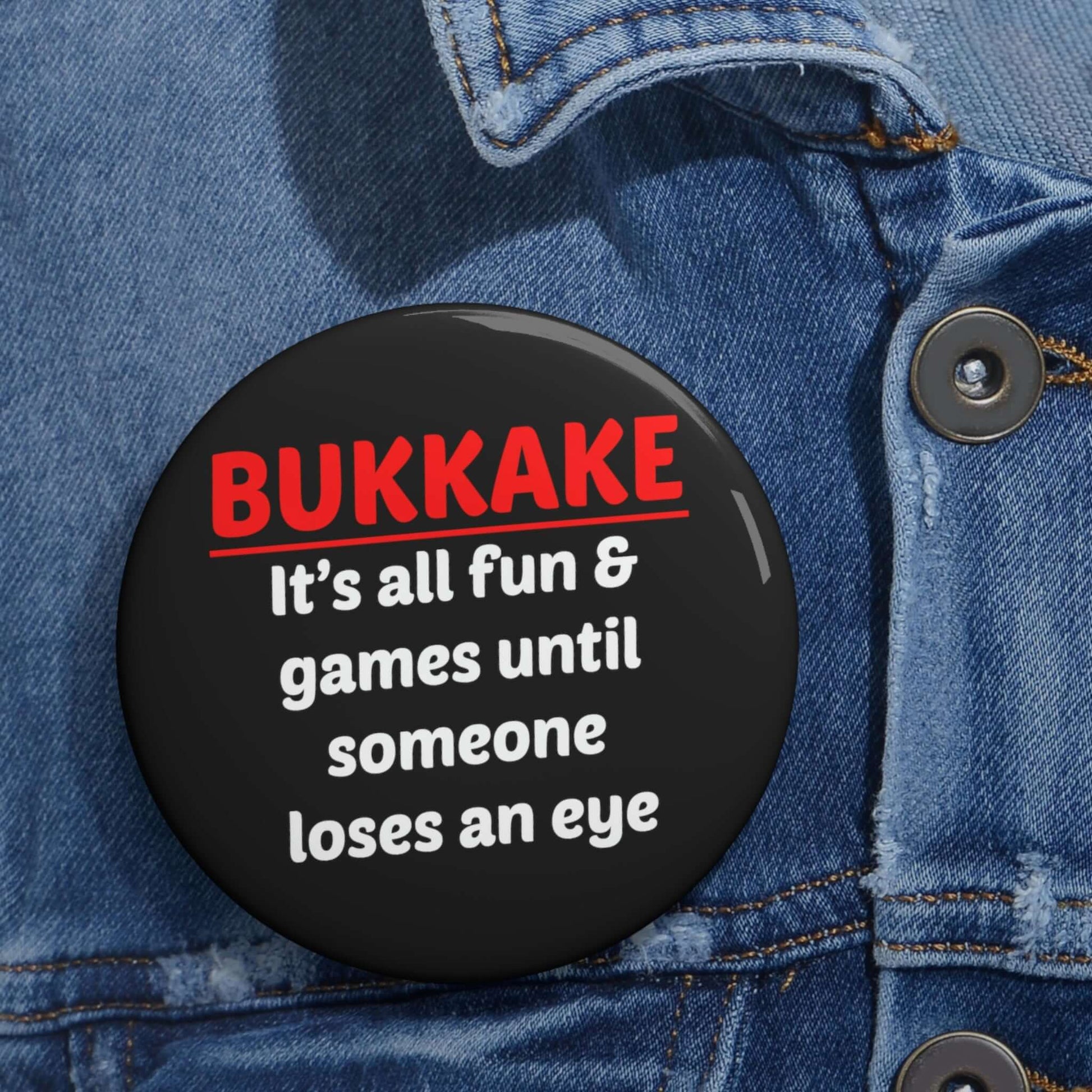 Black pinback button that says Bukkake it's all fun & games until someone loses an eye.