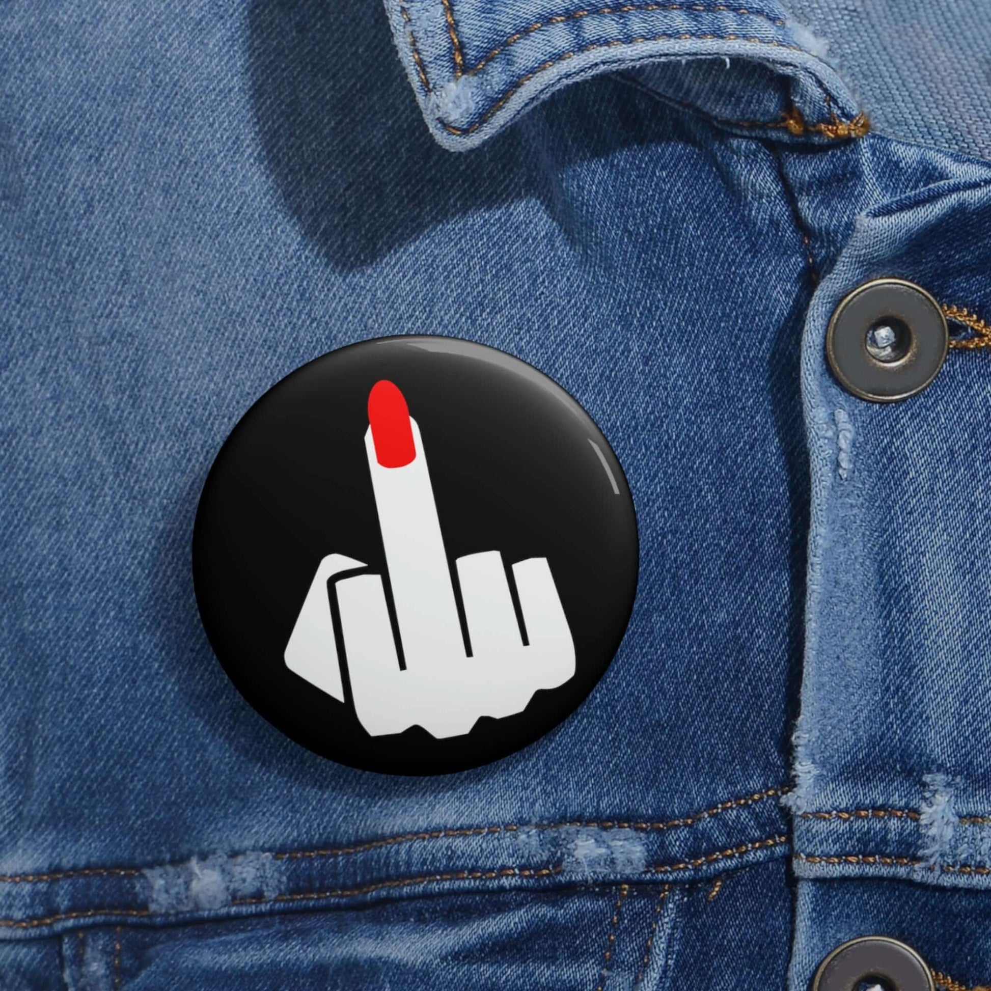 Pin-back button with silhouette of a ladies hand flipping the middle finger with a long red fingernail.