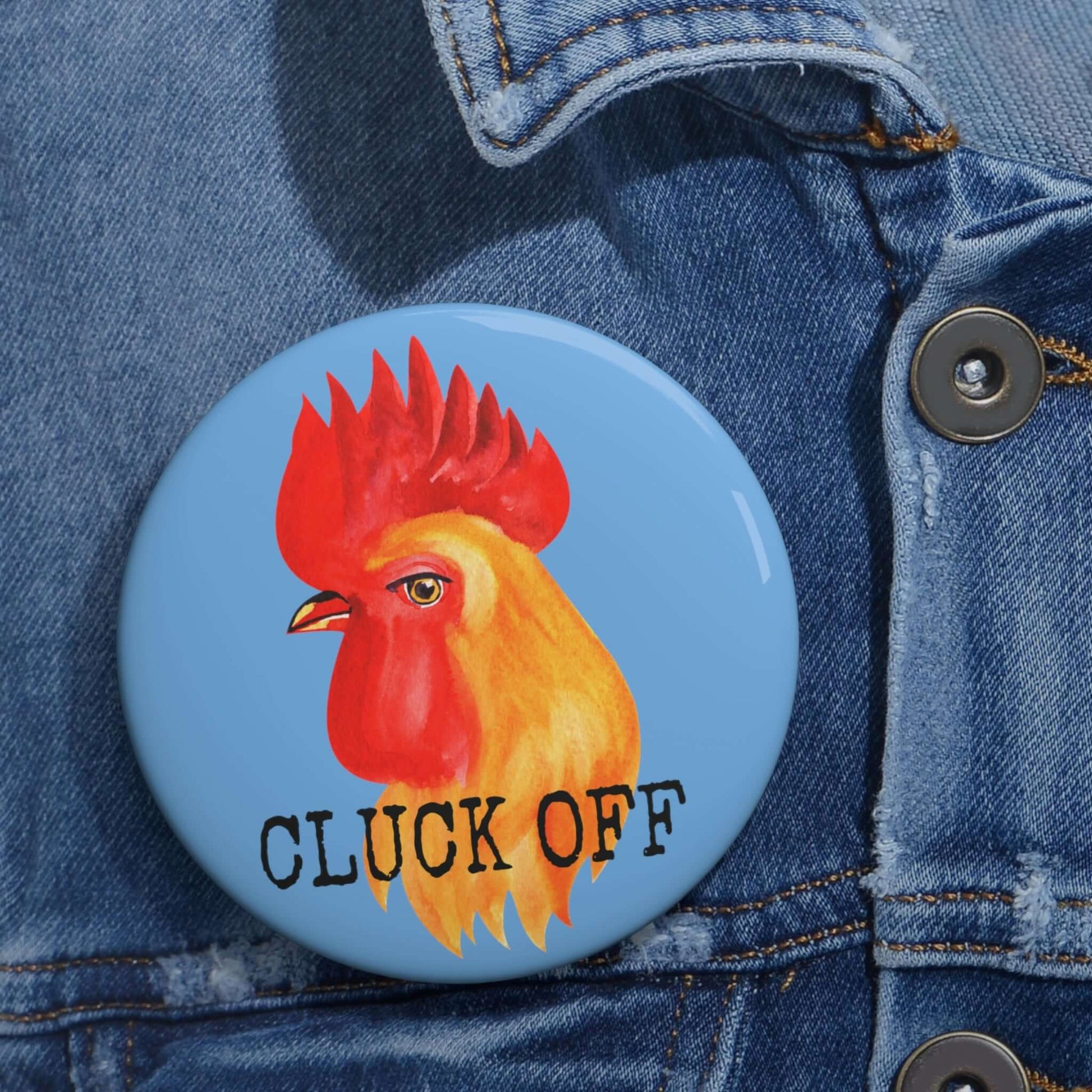 Light blue pun pinback button with image of a chicken and the words Cluck off beneath.