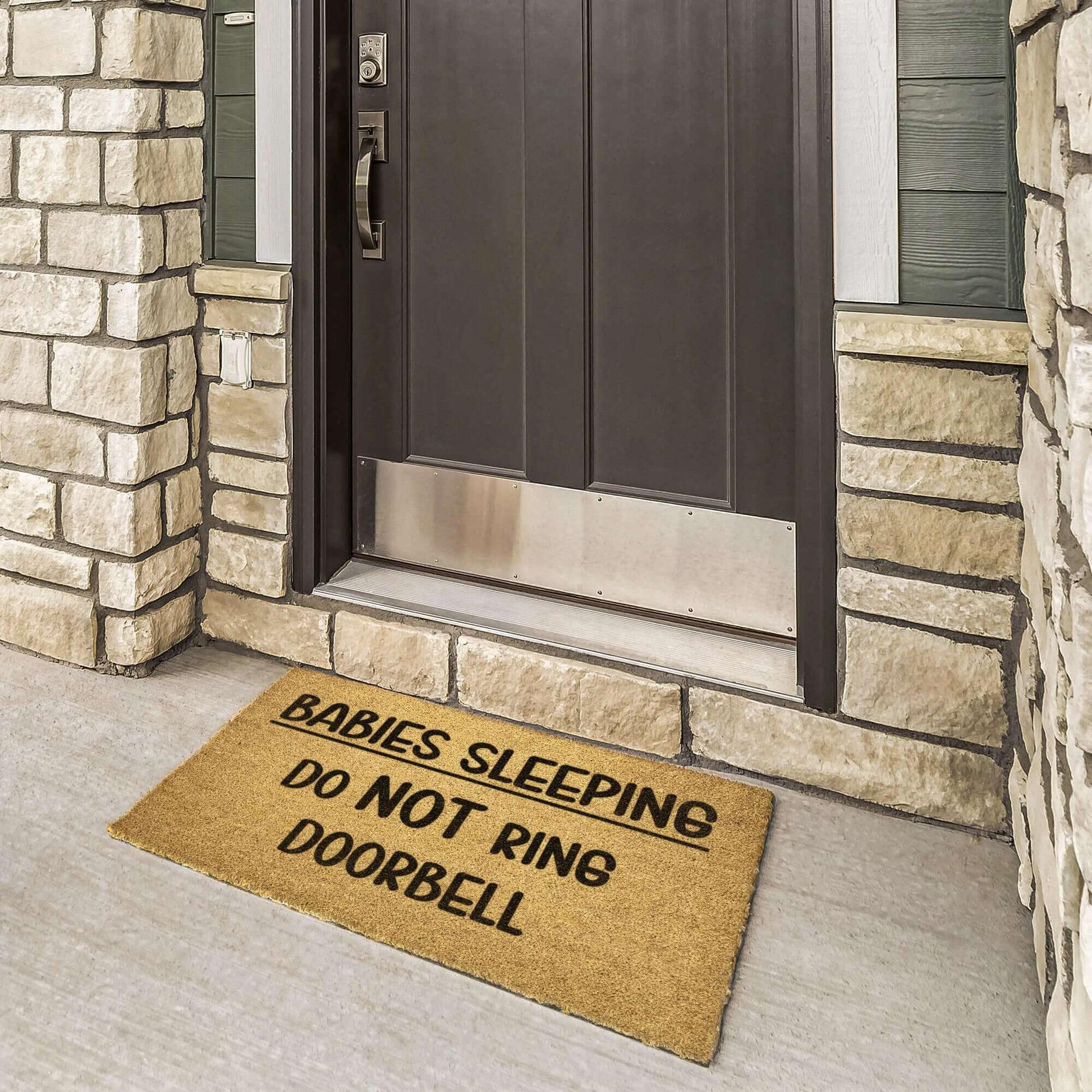 Outdoor doormat with the words Babies sleeping do NOT ring doorbell printed on it.