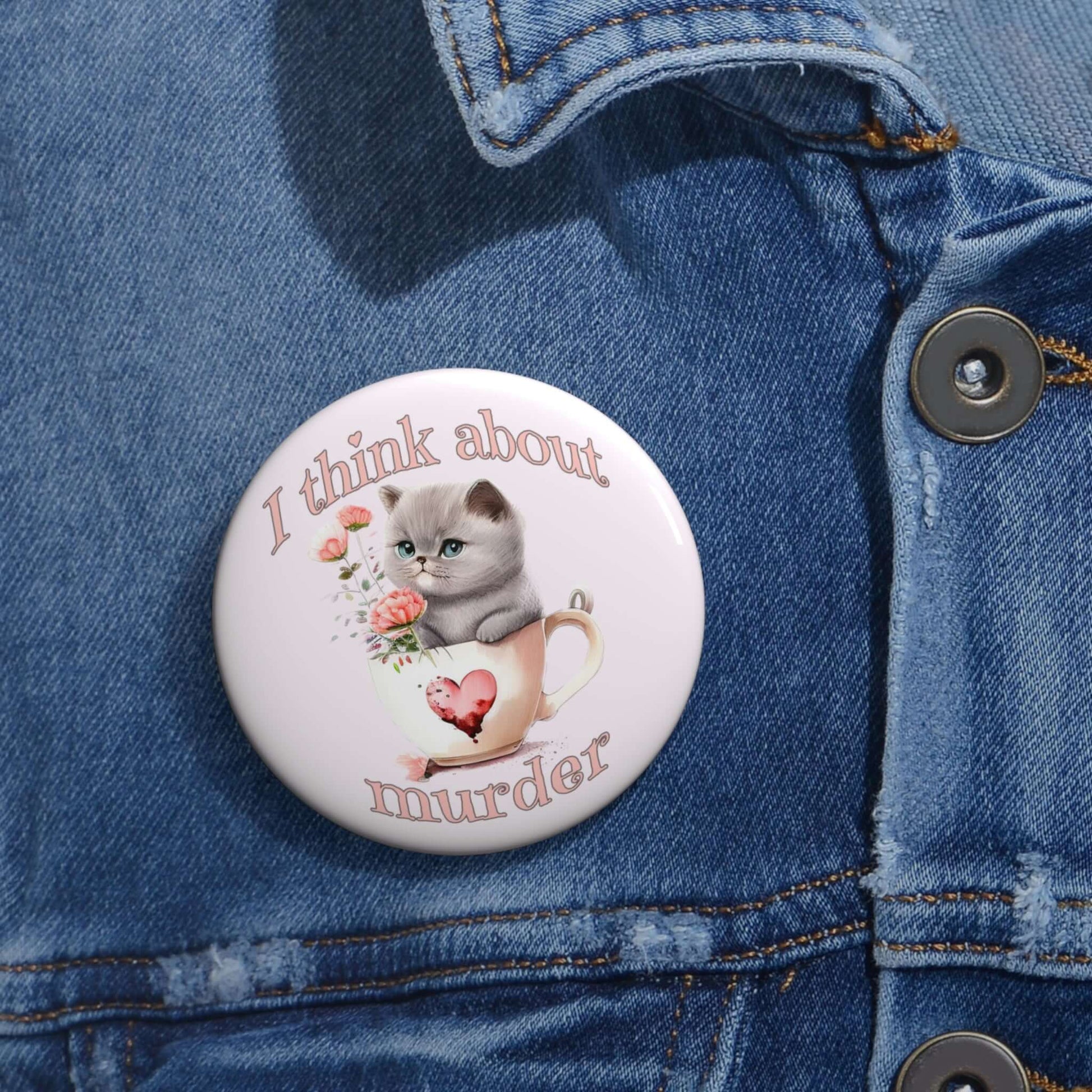 Sarcastic pin-back button that says I think about murder with image of cute fluffy kitten sitting in a teacup.