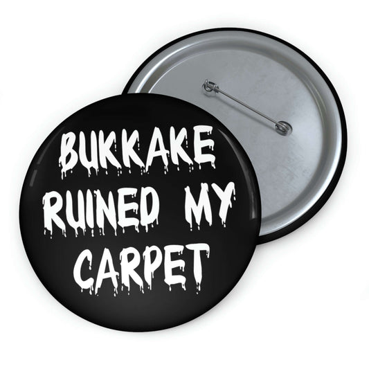 Black pinback button that says Bukkake ruined my carpet.