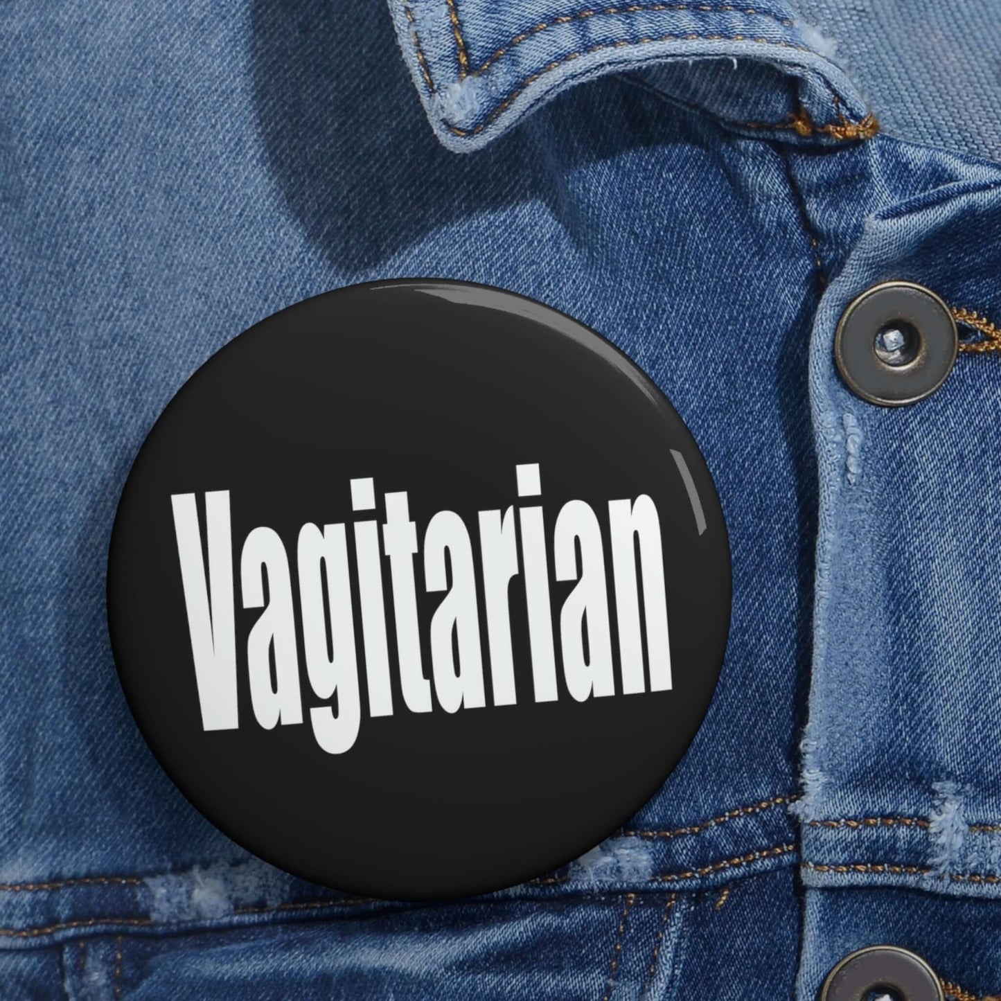 Black pinback button with the word Vagitarian printed on it.